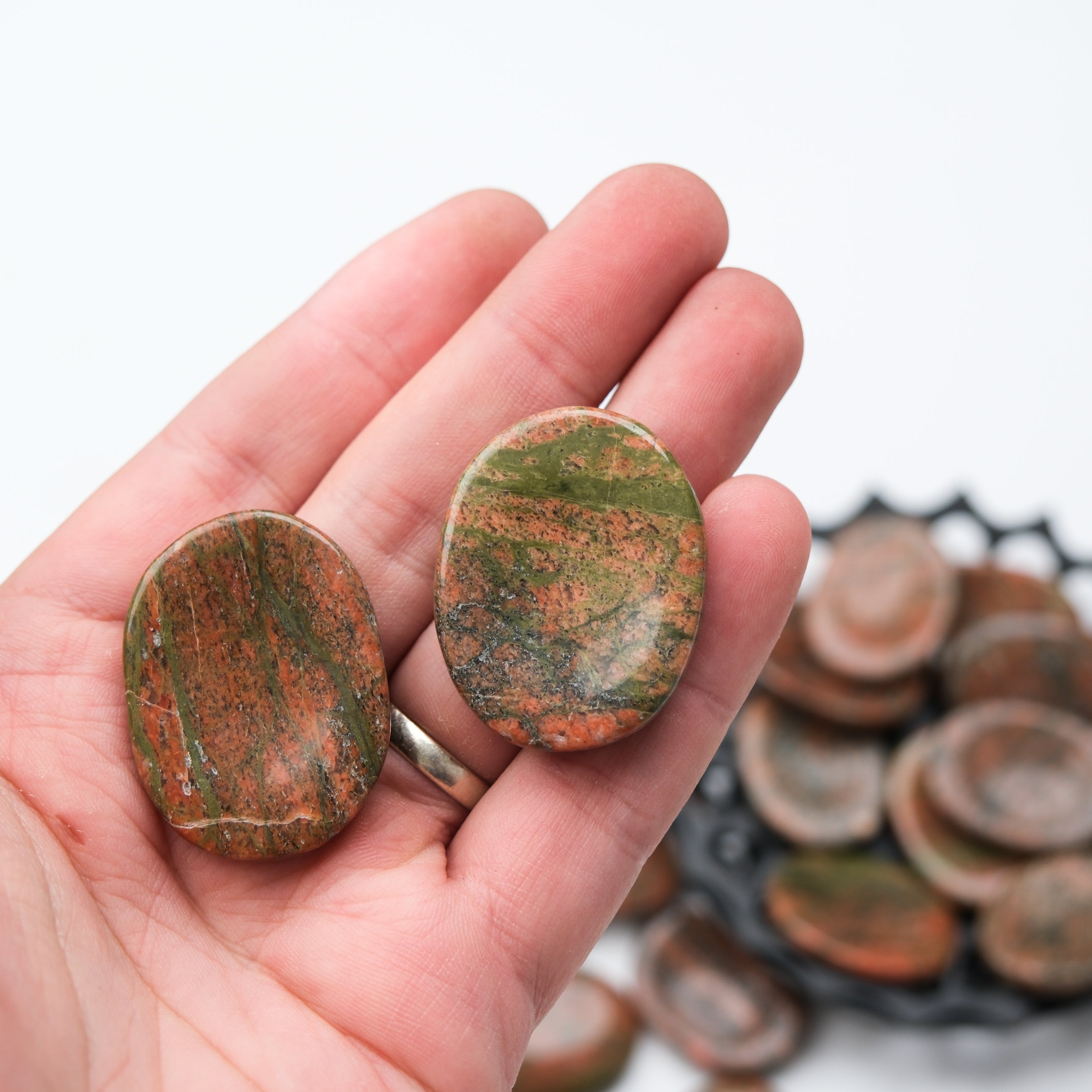 Unakite worry stone from Noctis Studio, smooth polished gemstone for stress relief and meditation, shown in close-up.