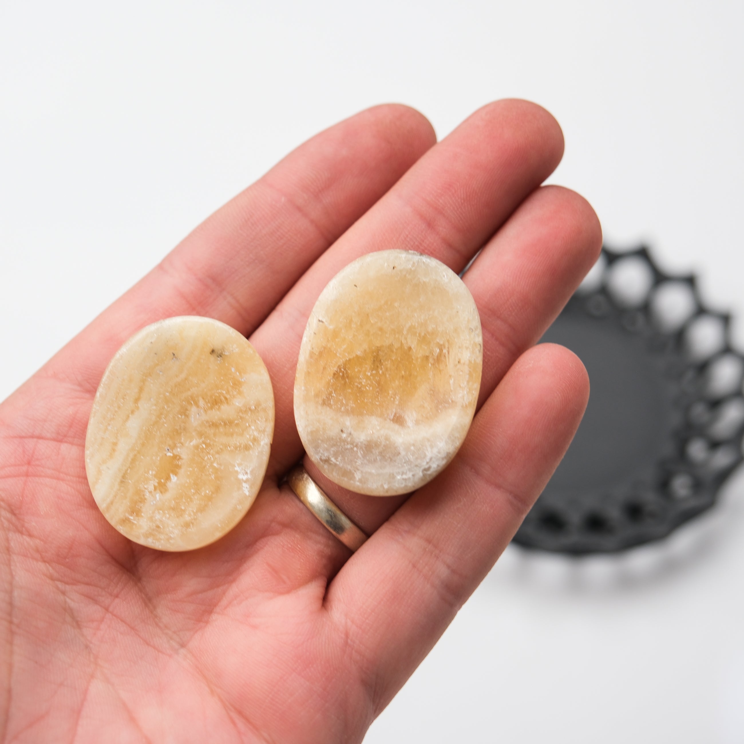 Orange banded calcite worry stone from Noctis Studio with smooth, polished surface and vibrant orange and white banding.