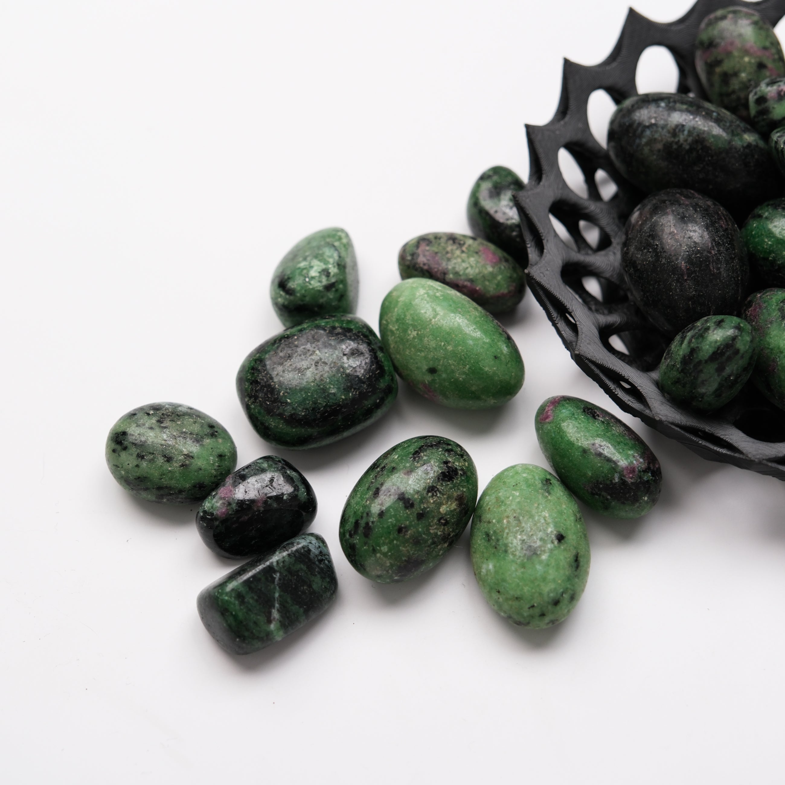 Ruby in Zoisite tumble stone from Noctis Studio showing a polished, colorful mineral with deep red and green hues.