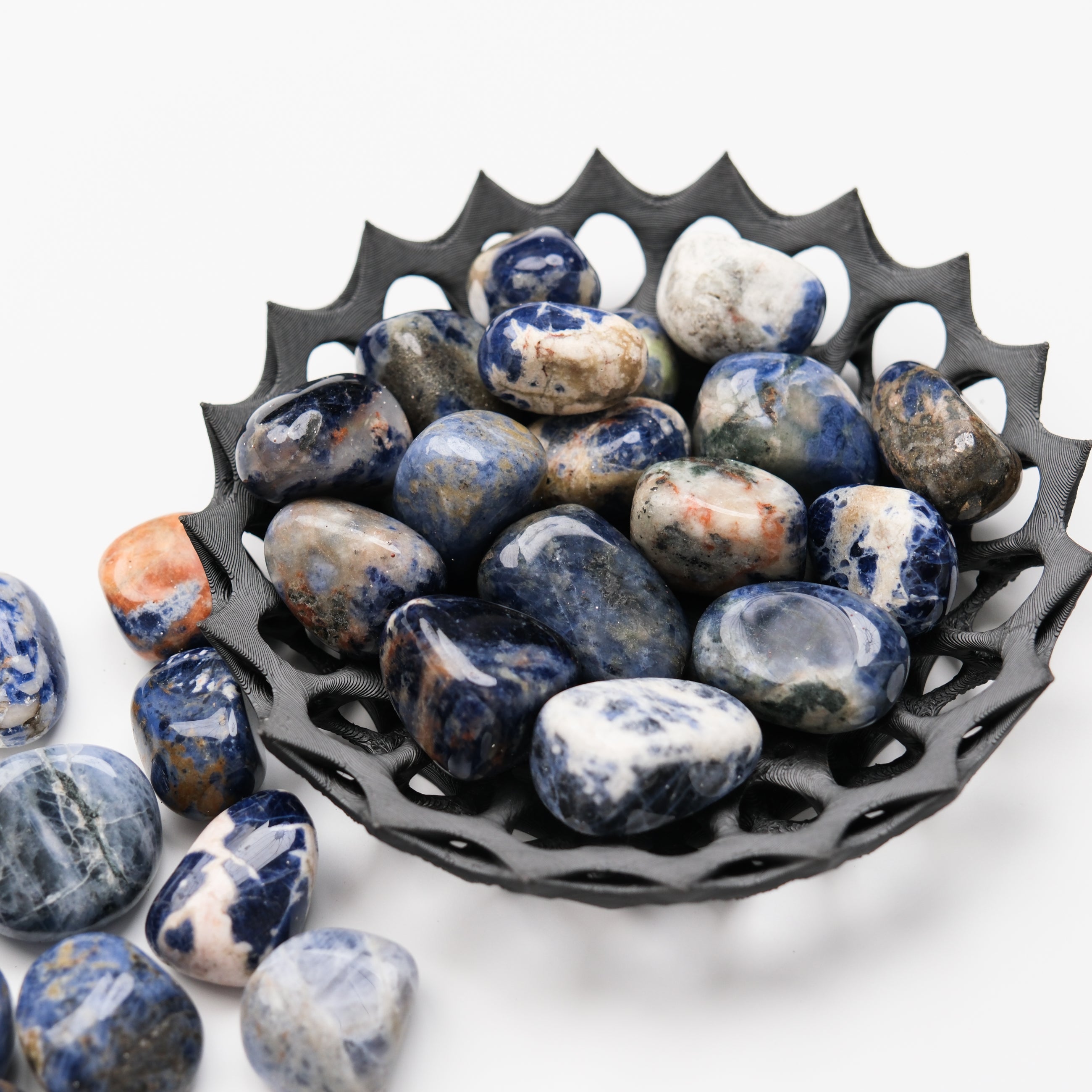 Blue sodalite tumble stone from Noctis Studio, polished gemstone with vibrant blue and white veining, natural mineral specimen.