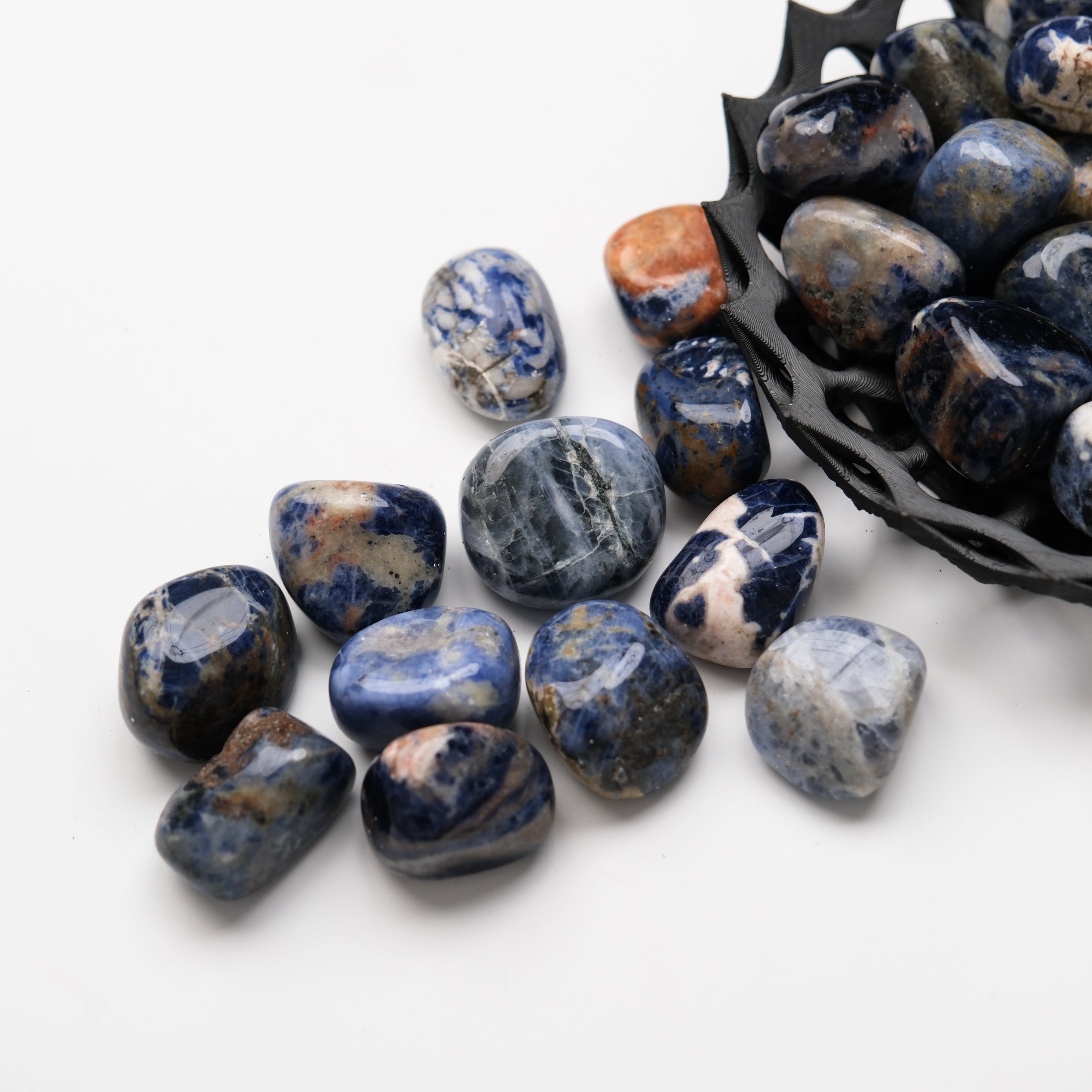 Sodalite tumble stone from Noctis Studio, smooth blue gemstone with white veining, displayed on a neutral background.