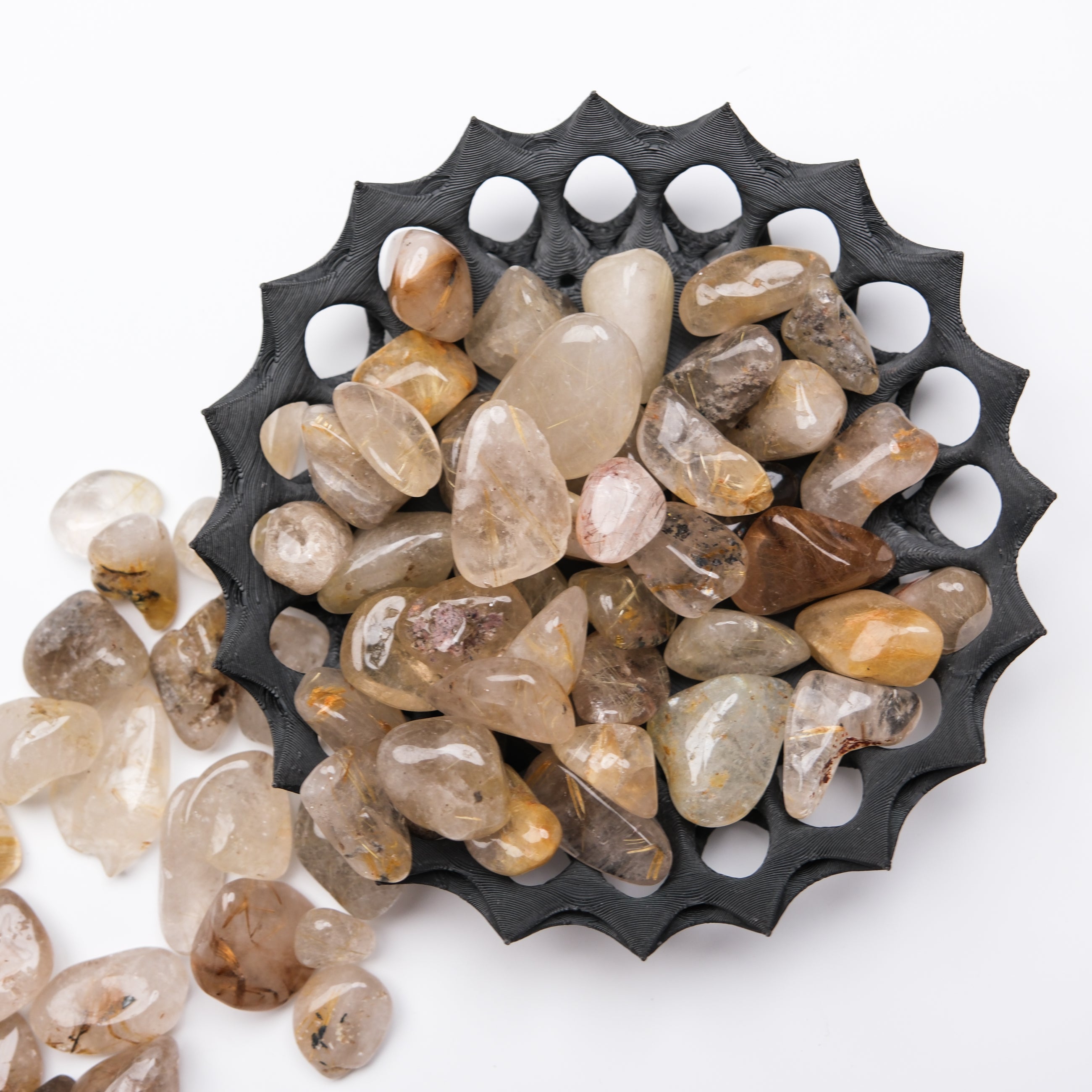 Golden rutilated quartz tumble stone from Noctis Studio, polished gemstone with golden needle inclusions and smooth surface.