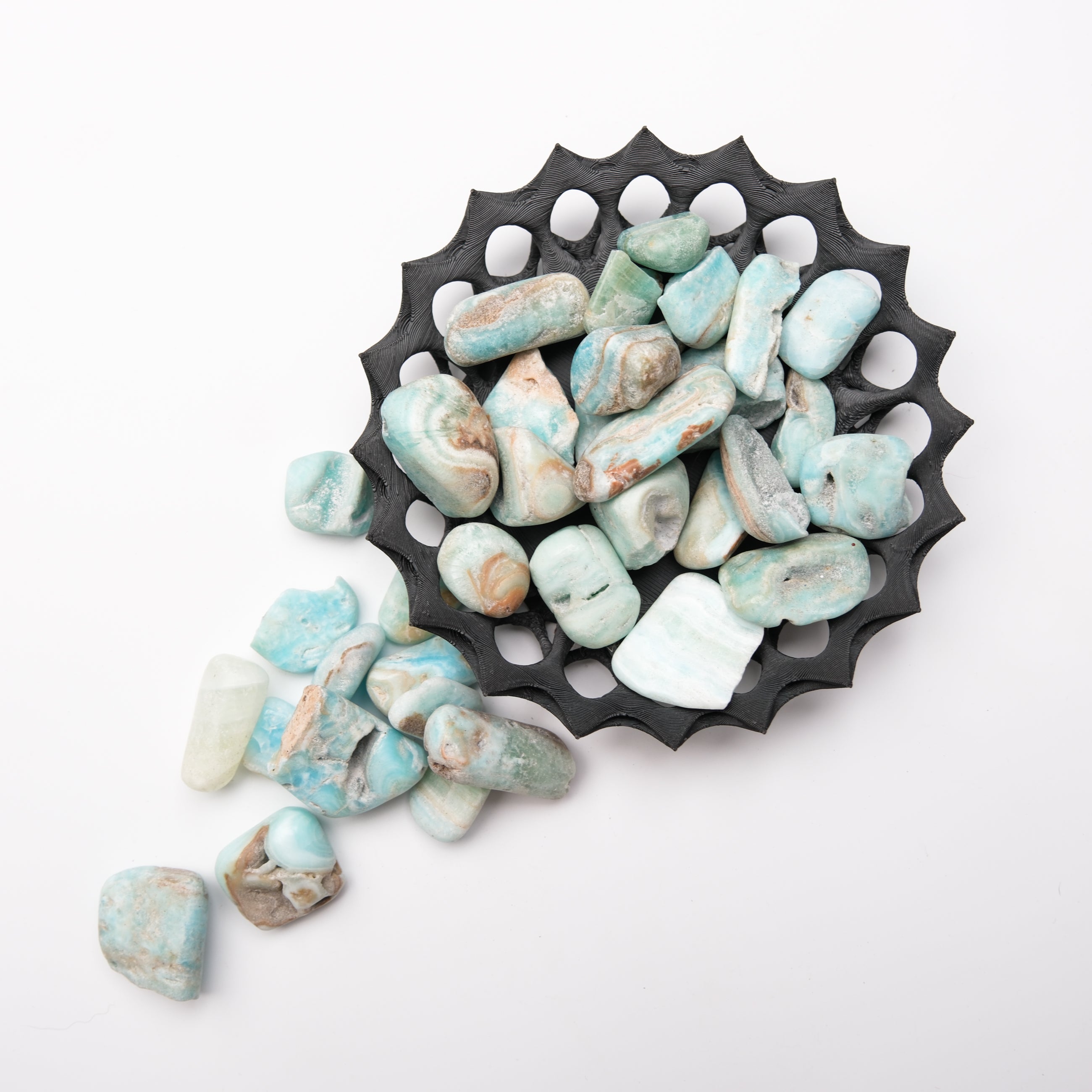 Caribbean Calcite tumble stone from Noctis Studio showing a smooth, polished mineral with vibrant blue and white swirls.