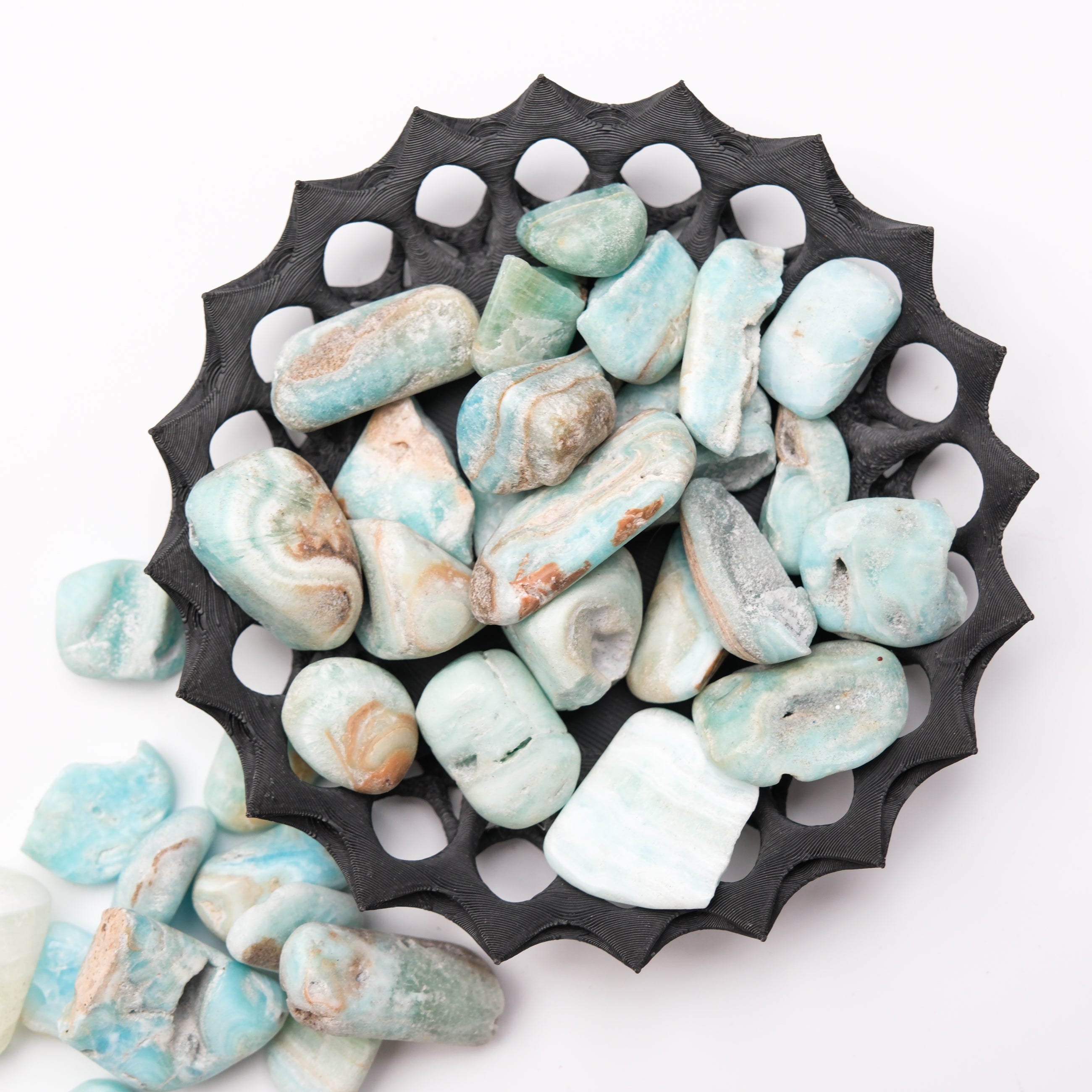 Caribbean Calcite tumble stone from Noctis Studio showing smooth, polished orange and teal mineral with natural patterns.