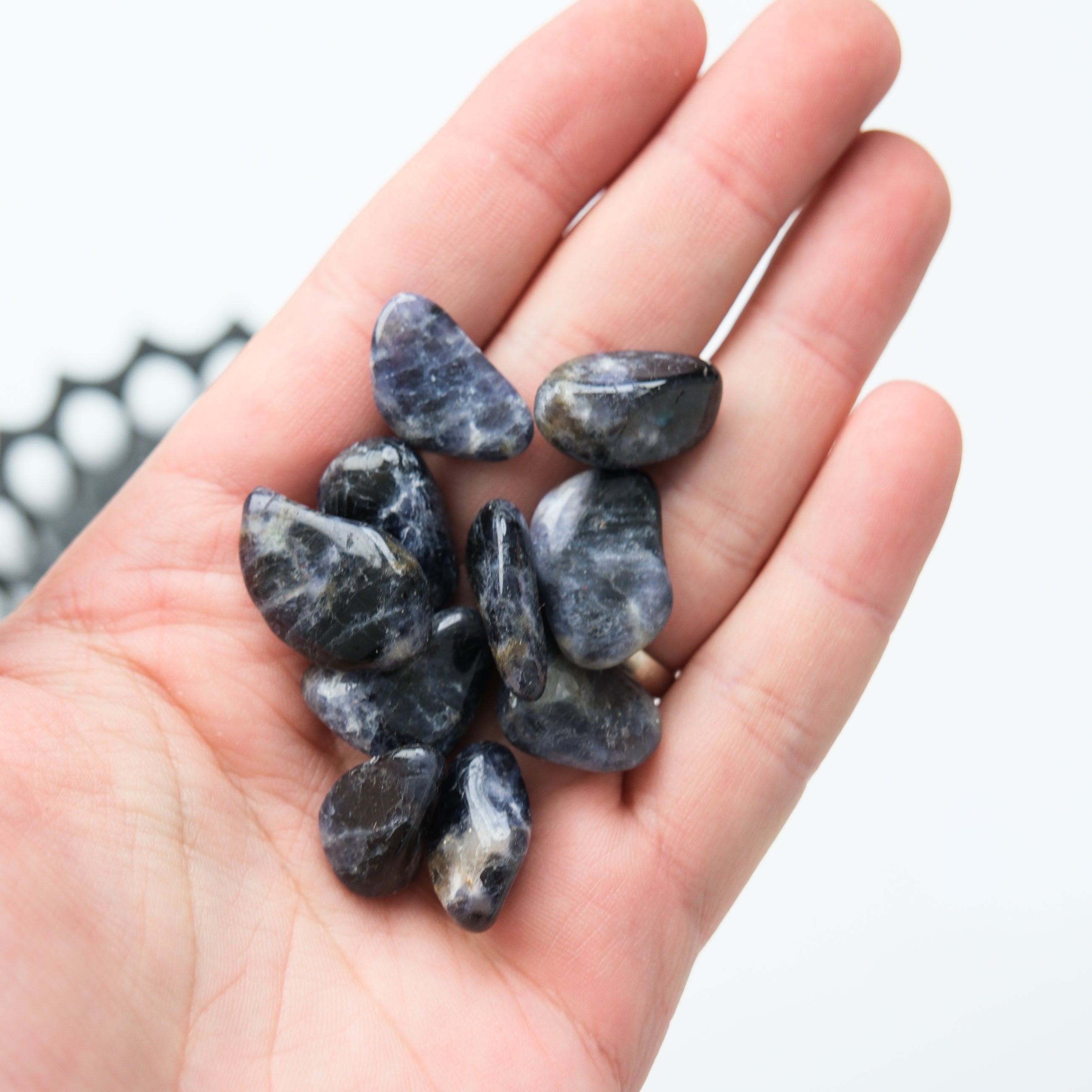 Iolite tumble stone from Noctis Studio showing smooth, polished blue and violet mineral with natural stone texture.