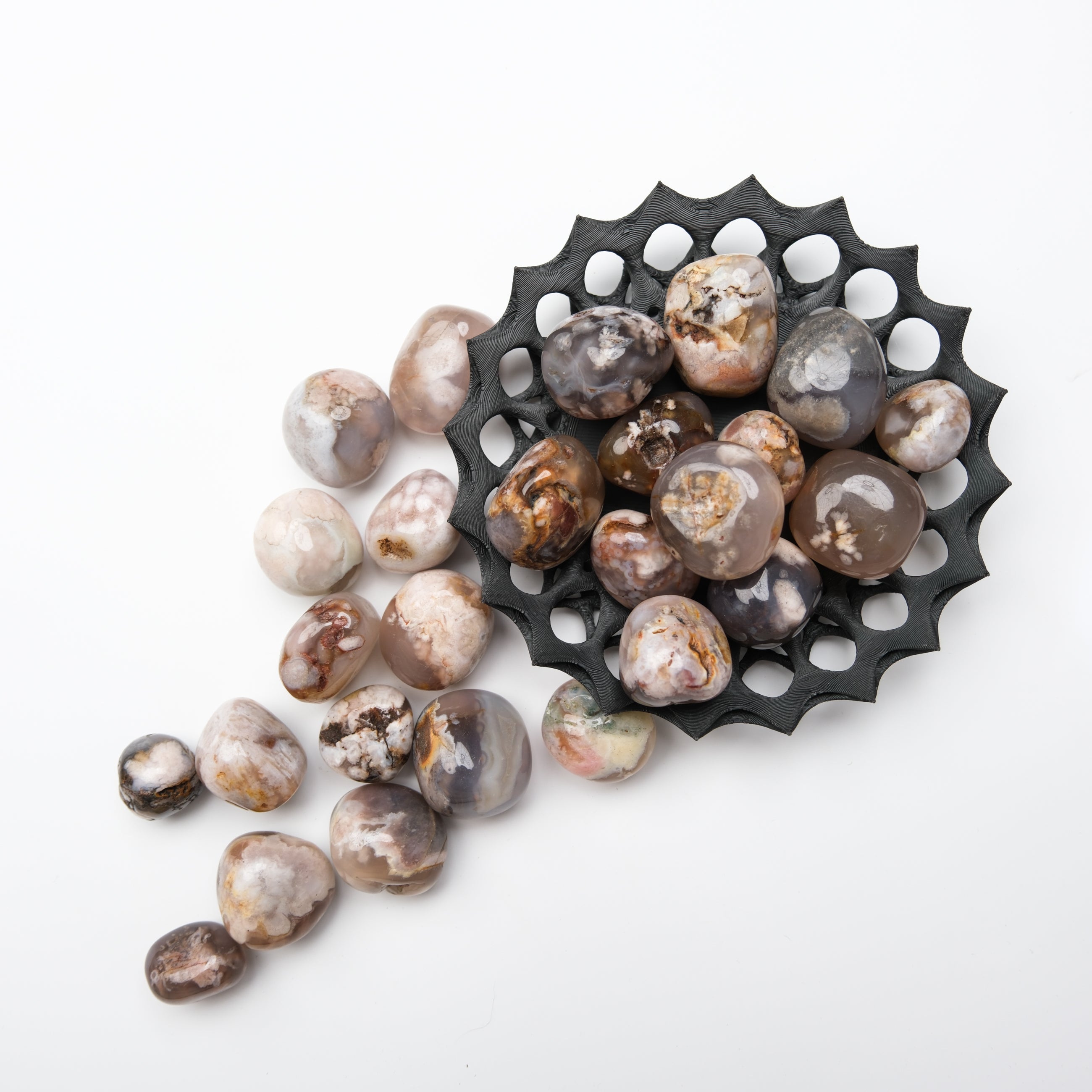 Black Flower Agate tumble stone from Noctis Studio, showcasing smooth, polished gemstone with floral patterns and rich black color.