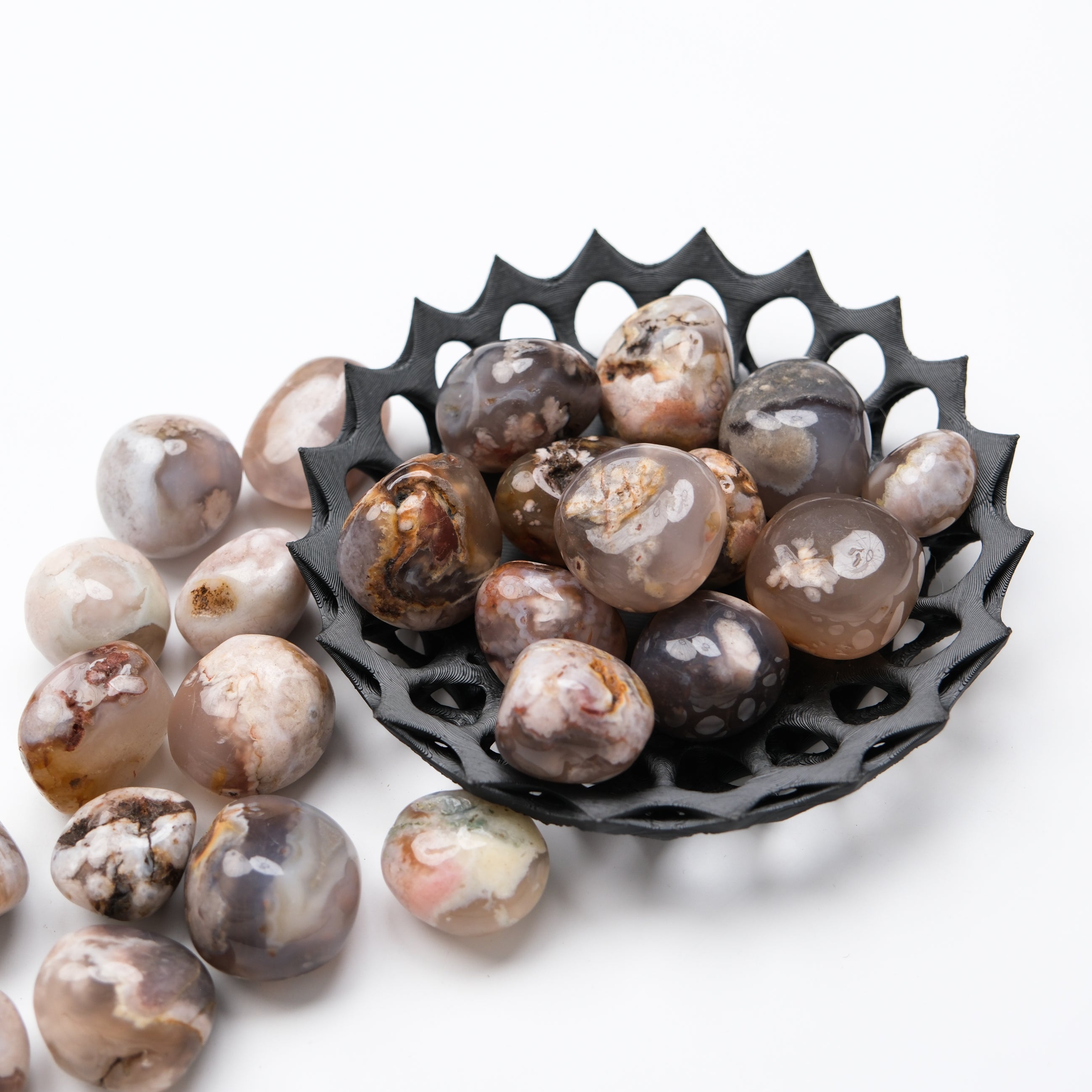 Black Flower Agate tumble stone from Noctis Studio, smooth round gemstone with floral pattern, suitable for meditation and display.