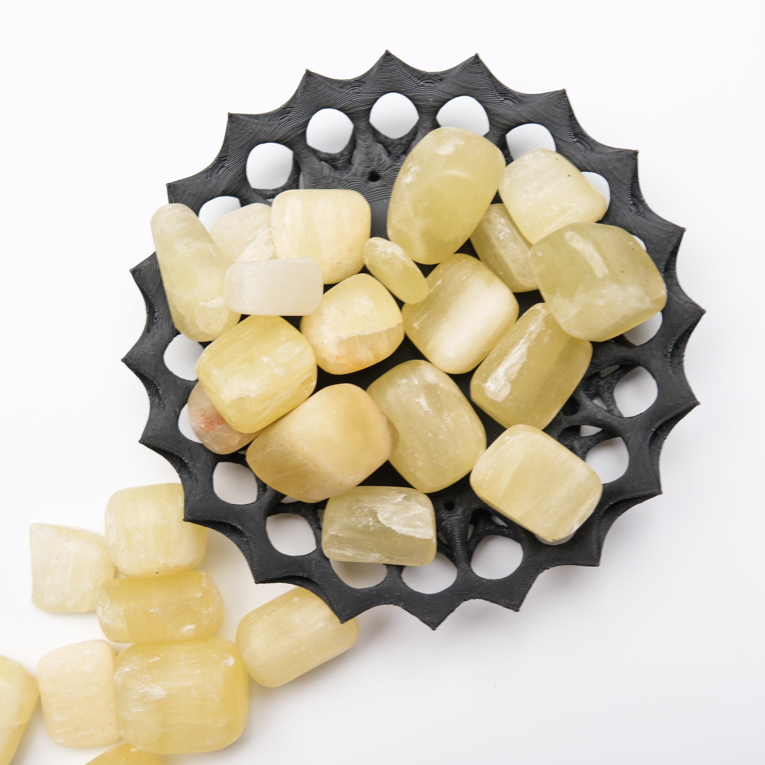 Lemon Calcite tumble stone from Noctis Studio, showcasing a smooth, polished yellow mineral with natural veining and vibrant color.