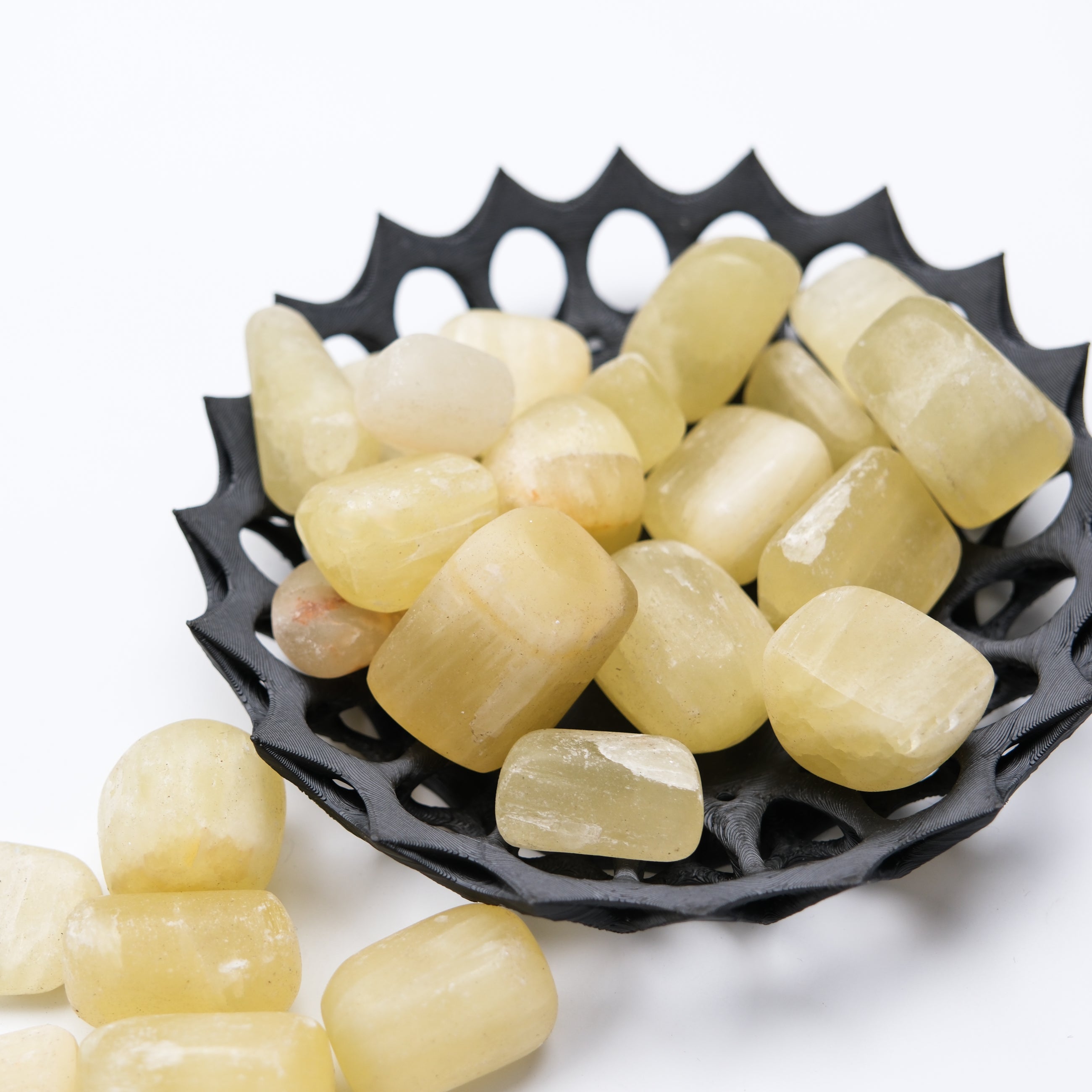 Lemon Calcite tumble stone by Noctis Studio, showing a polished yellow mineral with smooth rounded edges and natural stone texture.