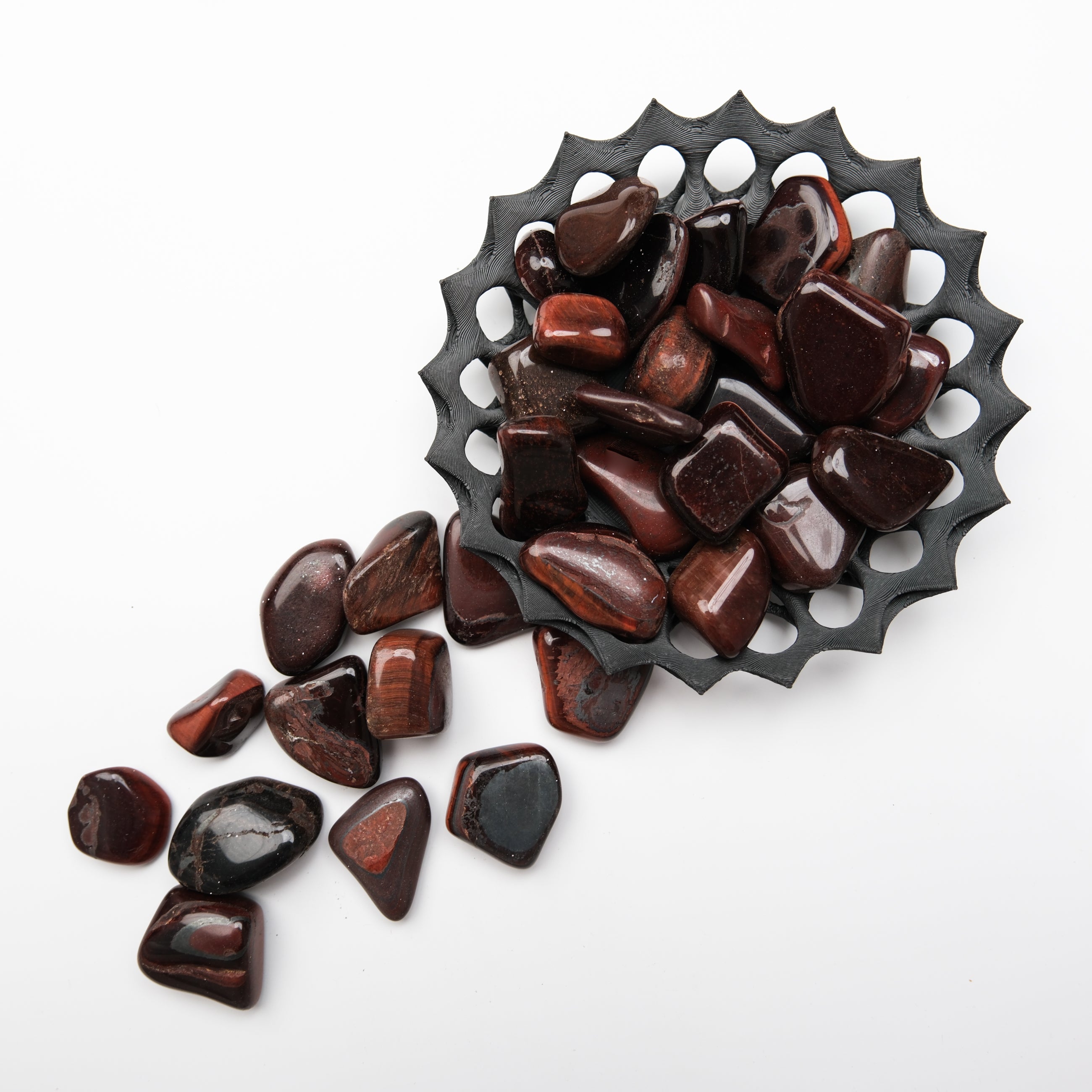 Red Tigers Eye tumble stone from Noctis Studio, smooth polished gemstone with rich red and golden-brown banding.