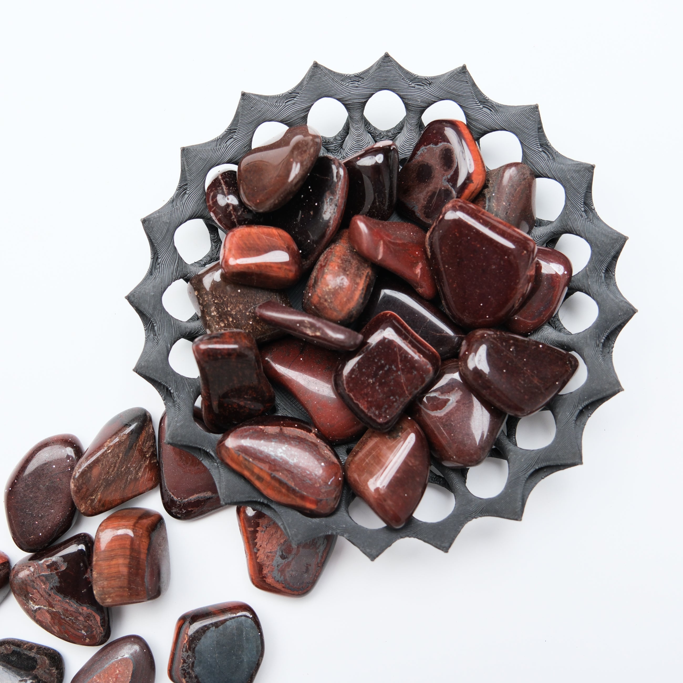 Red Tigers Eye tumble stone from Noctis Studio, showcasing its polished, reddish-brown gemstone with natural banding and smooth surface.