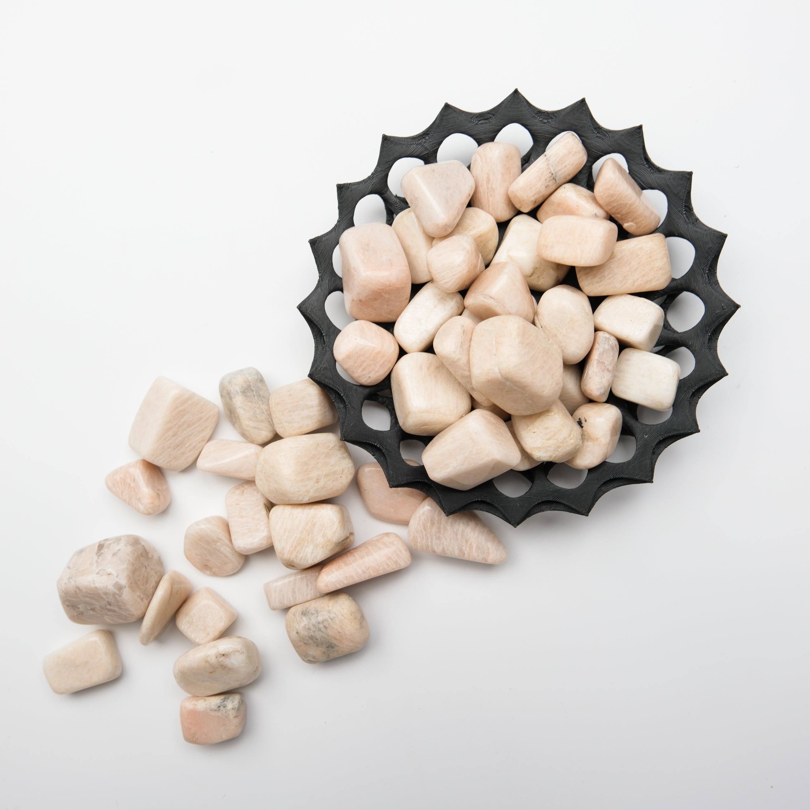 Cream moonstone tumble stone from Noctis Studio, showing smooth, polished surface with soft, milky color and subtle glow.