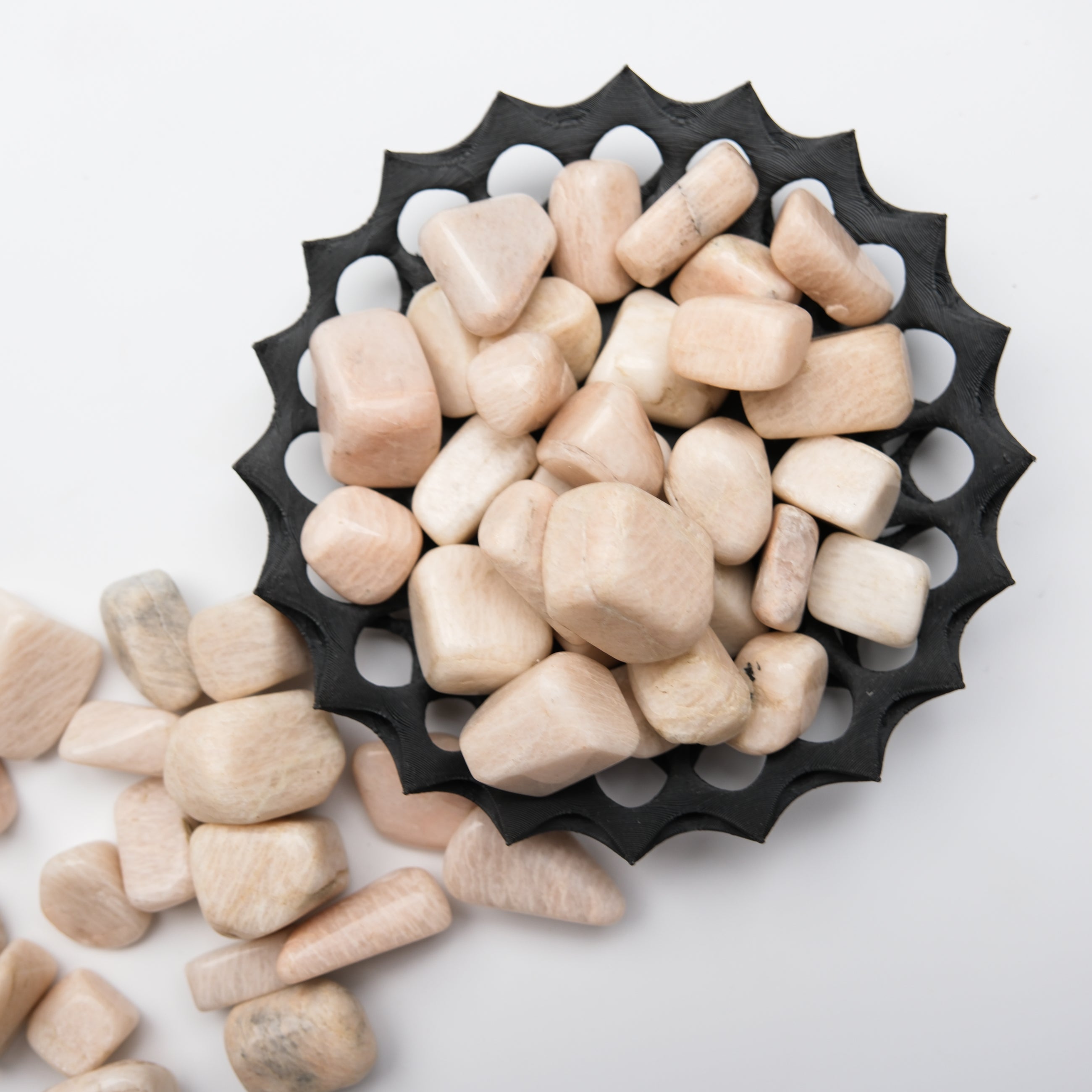 Cream Moonstone tumble stone from Noctis Studio showing smooth, polished surface with creamy, iridescent glow.