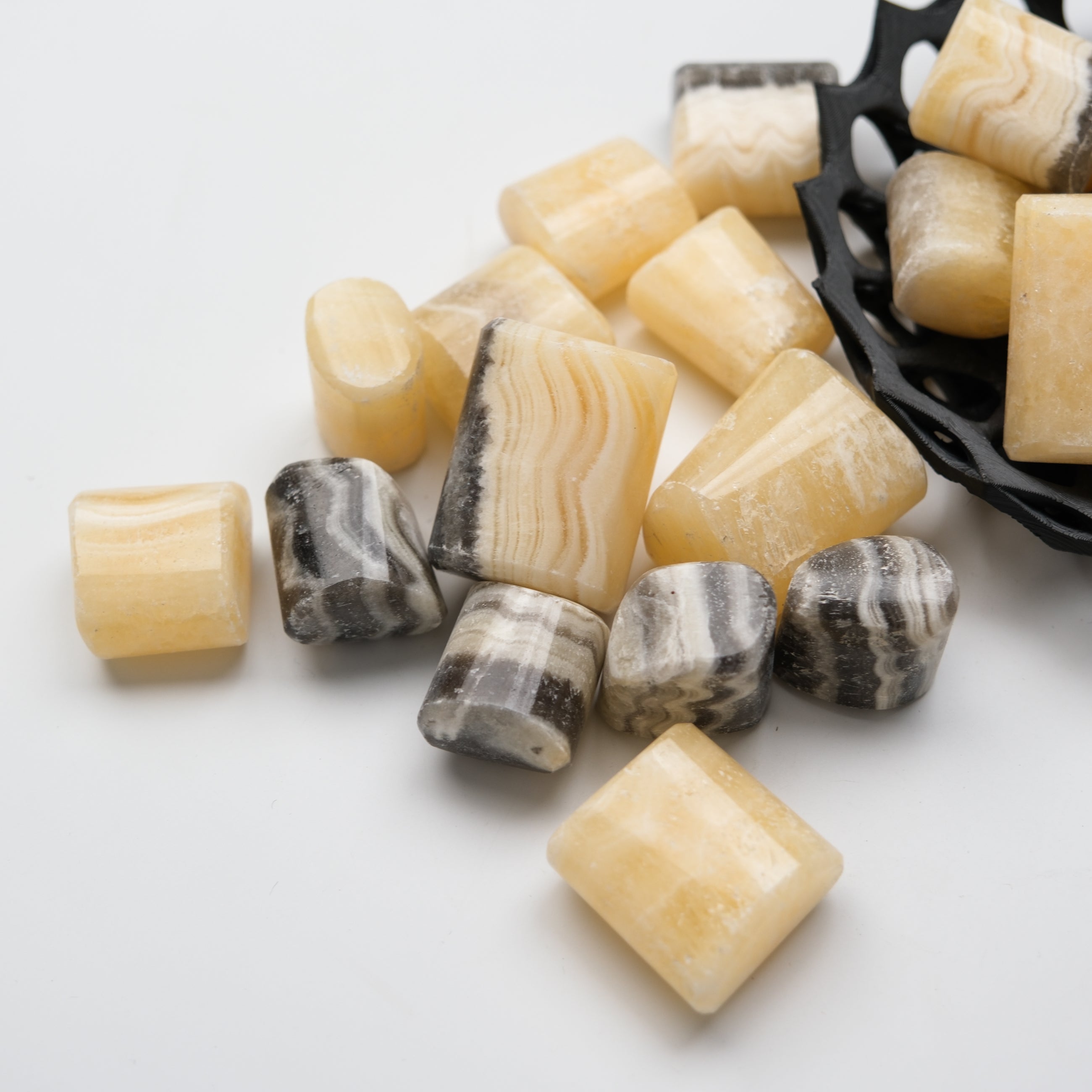 Orange Banded Calcite tumble stone from Noctis Studio, smooth polished mineral with vibrant orange banding and natural crystalline texture.