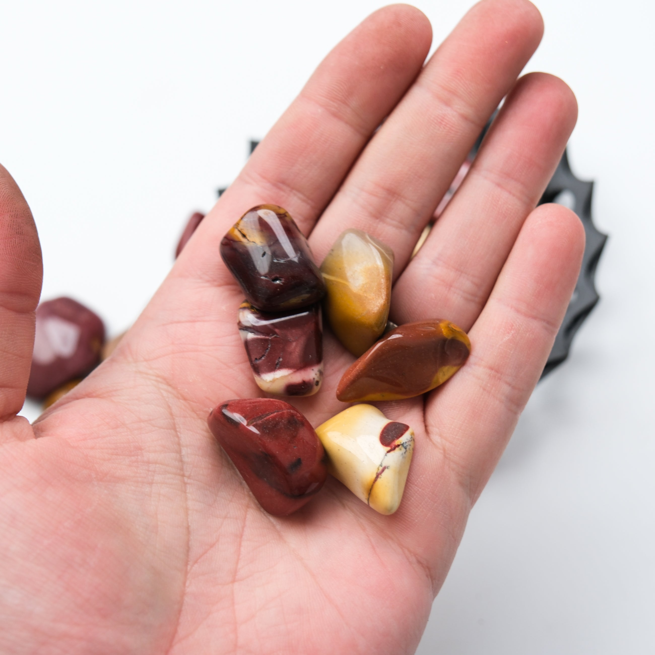 Mookaite Tumble Stone from Noctis Studio showcasing earthy red and yellow hues with smooth polished surface.