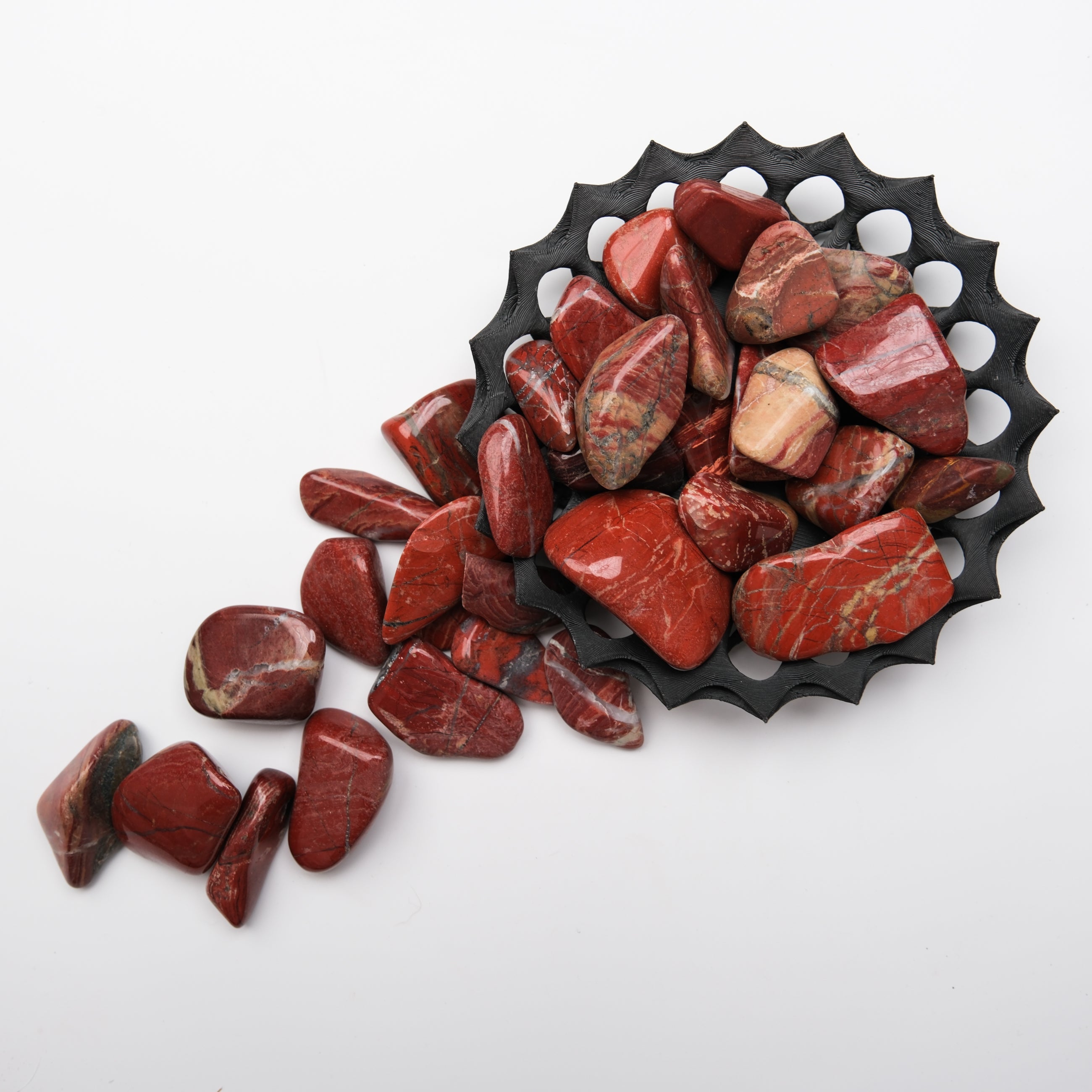 Red Jasper tumble stone from Noctis Studio, smooth polished gemstone with vibrant red color and natural stone pattern.