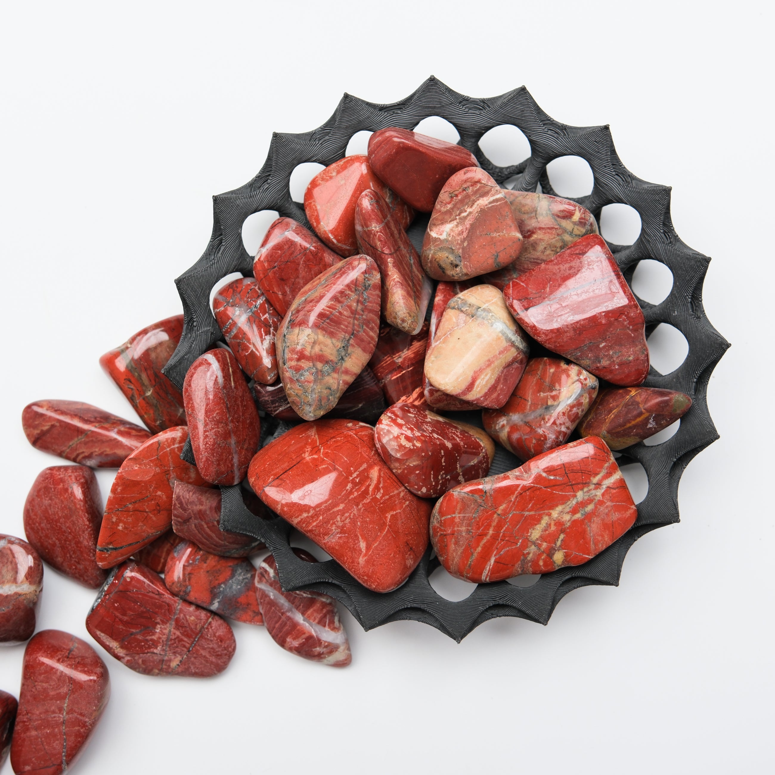 Red Jasper tumble stone from Noctis Studio, showcasing a polished, deep red gemstone with natural patterns and smooth surface.