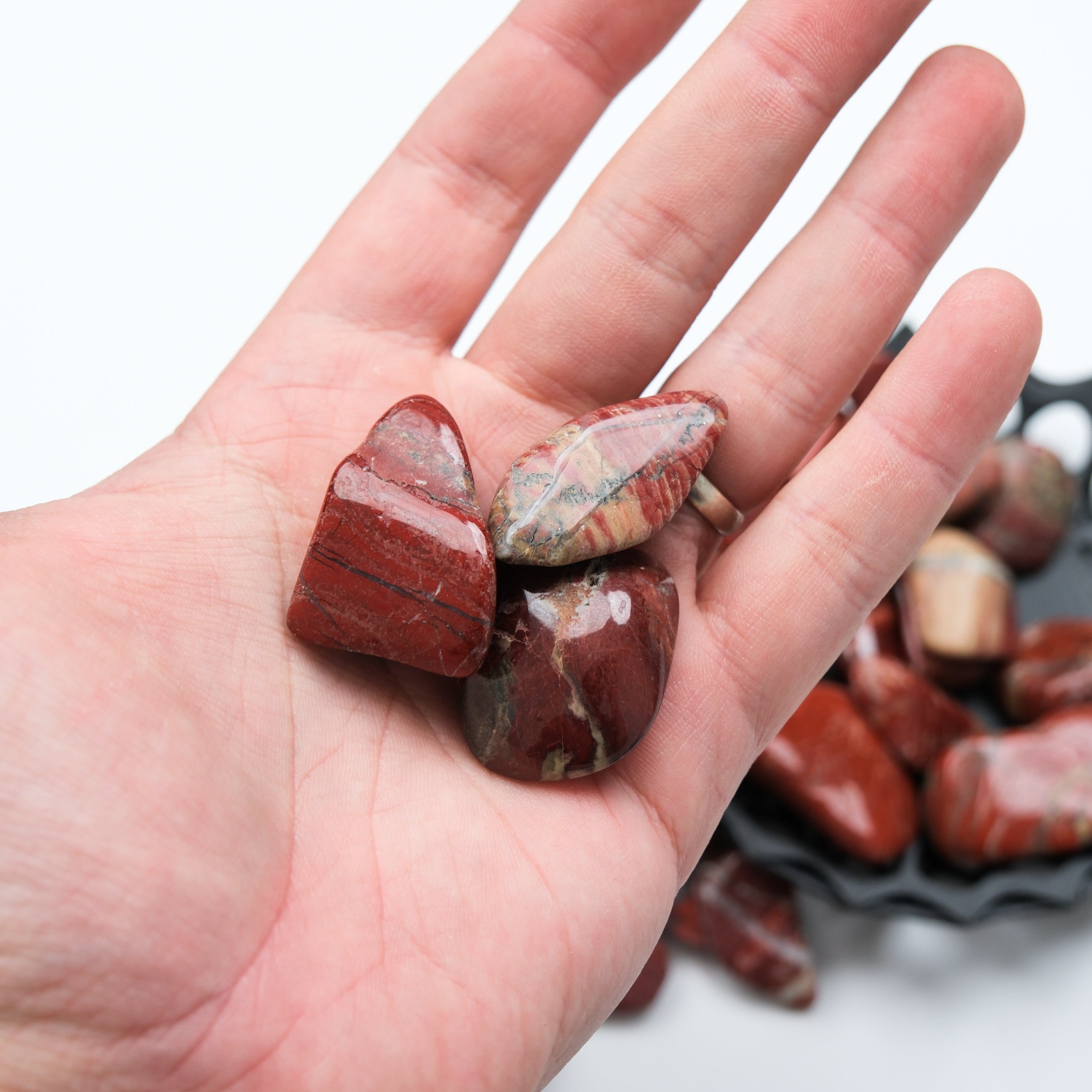 Red Jasper tumble stone from Noctis Studio, polished red gemstone with smooth, rounded surface and vibrant color.