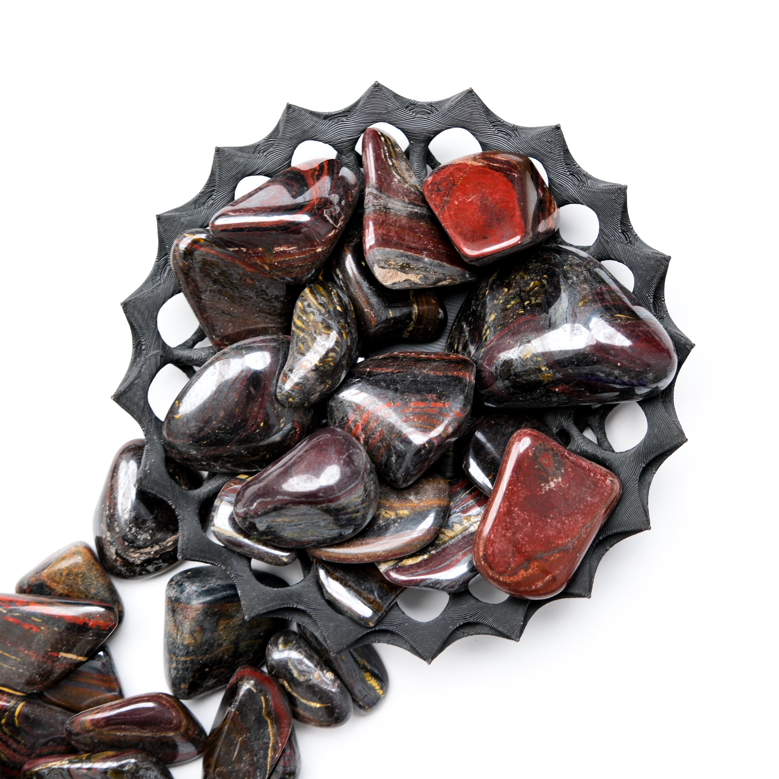 Red Tigers Iron Tumble Stone from Noctis Studio, showing a polished red stone with intricate natural patterns and smooth rounded edges.