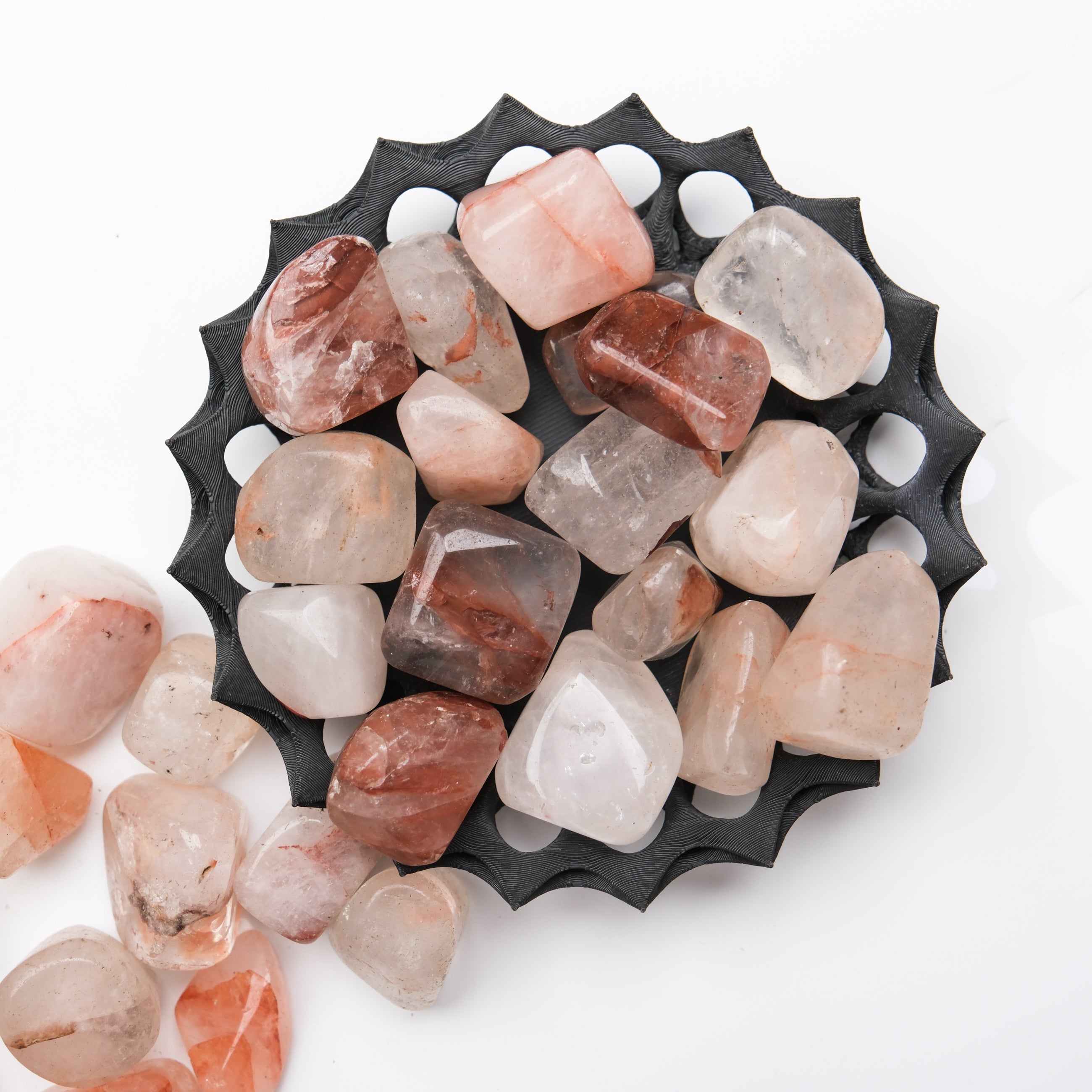 Hematoid Quartz tumble stone from Noctis Studio showing a polished, rounded mineral with red and brown hues on a plain background.