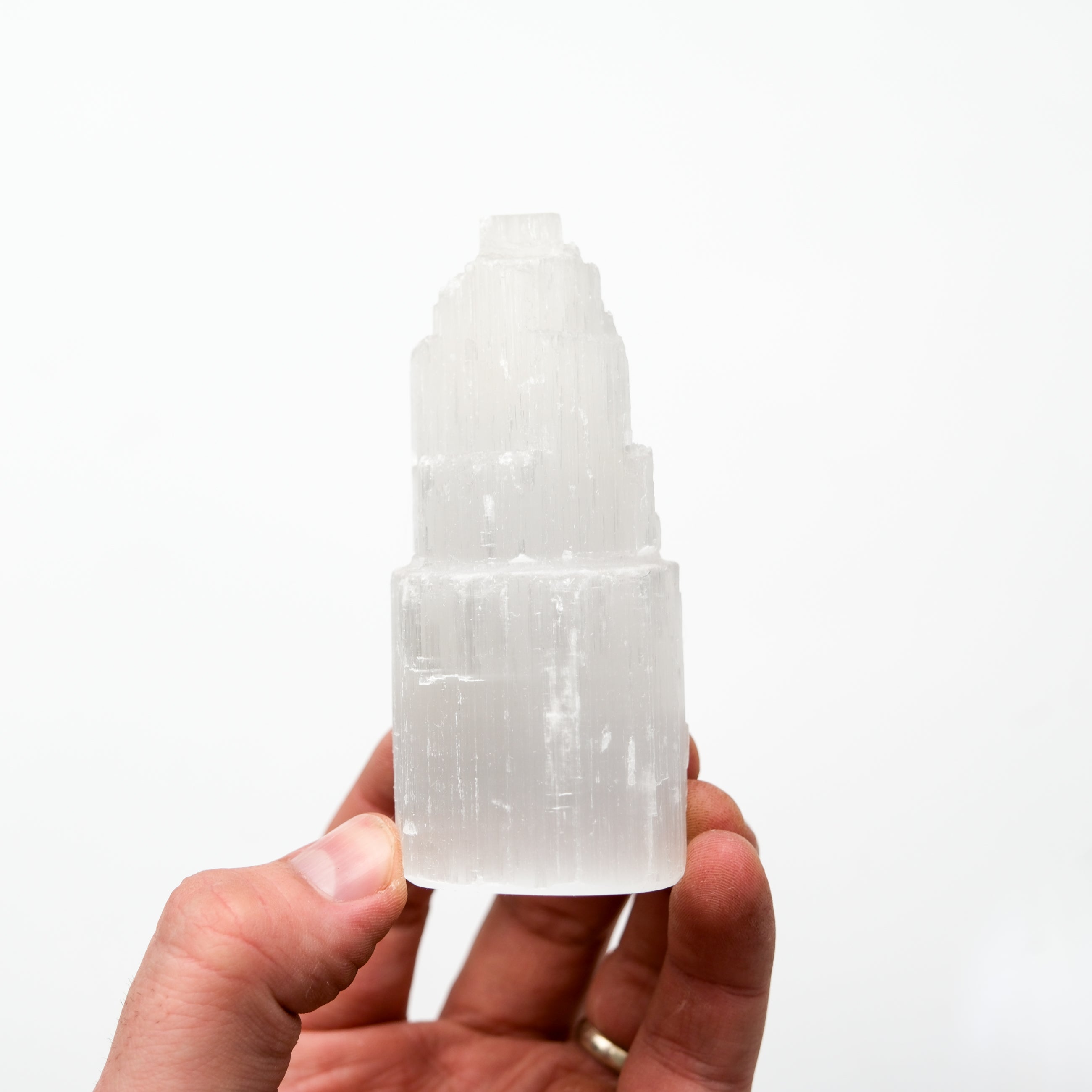 Noctis Studio selenite pillar displaying smooth, translucent white crystal with natural striations and a polished finish.