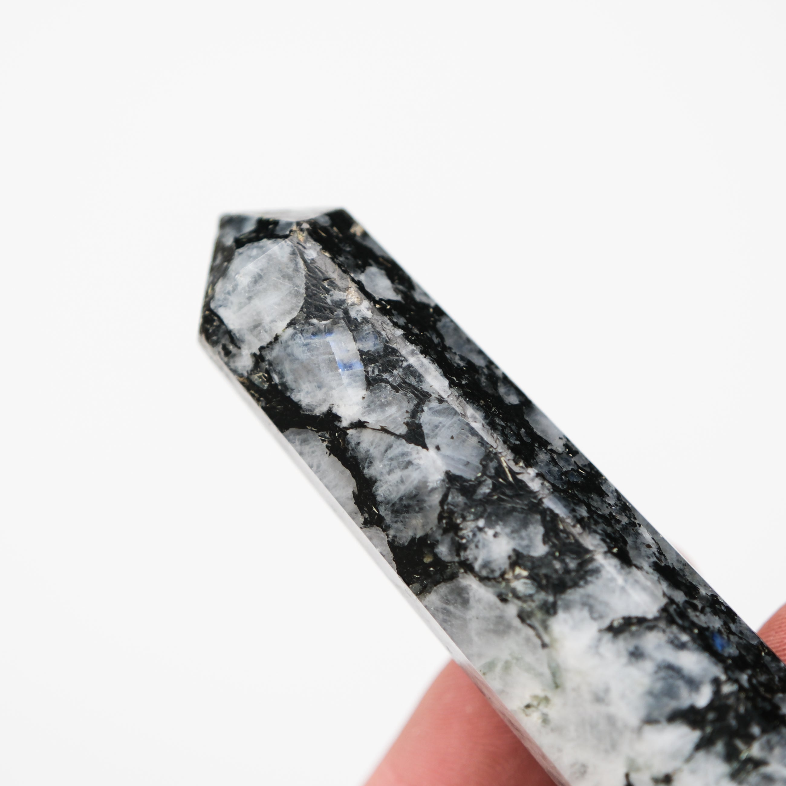 Noctis Studio moonstone point pillar, polished gemstone with a smooth, curved shape and luminous, iridescent surface.