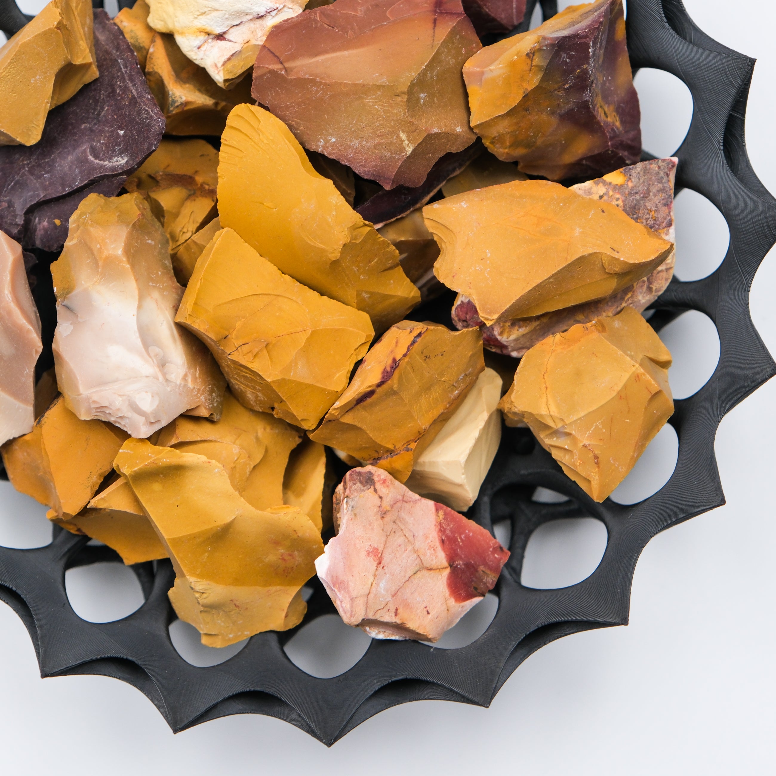 Natural Mookaite rough gemstone from Noctis Studio, showcasing its earthy red, yellow, and brown mineral hues with a textured surface.