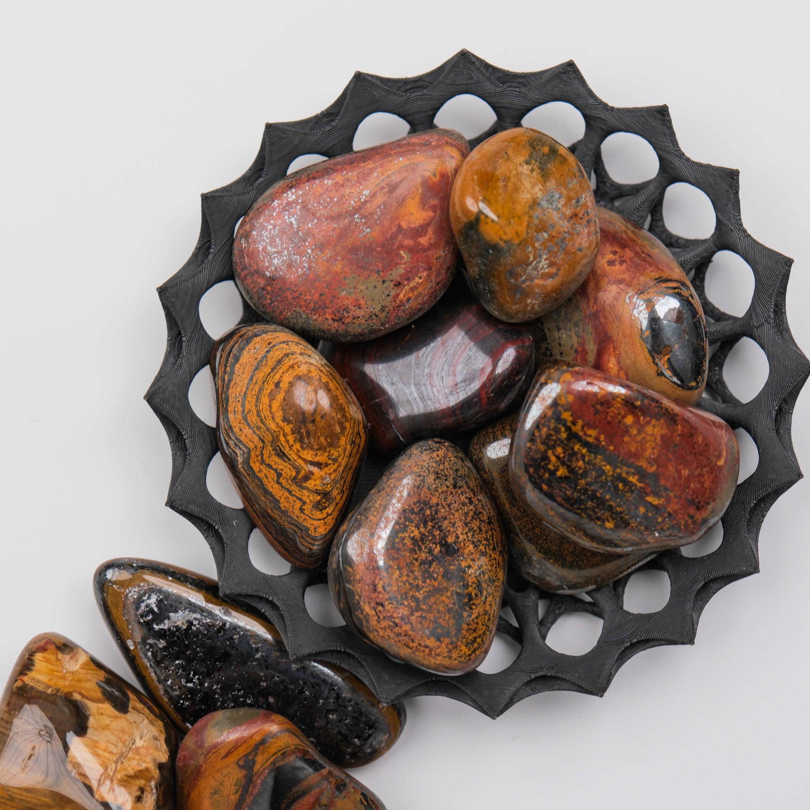 Noctis Studio Tigers Iron Tumble Stone showing polished, rounded stone with distinctive tiger's eye coloration and smooth surface.