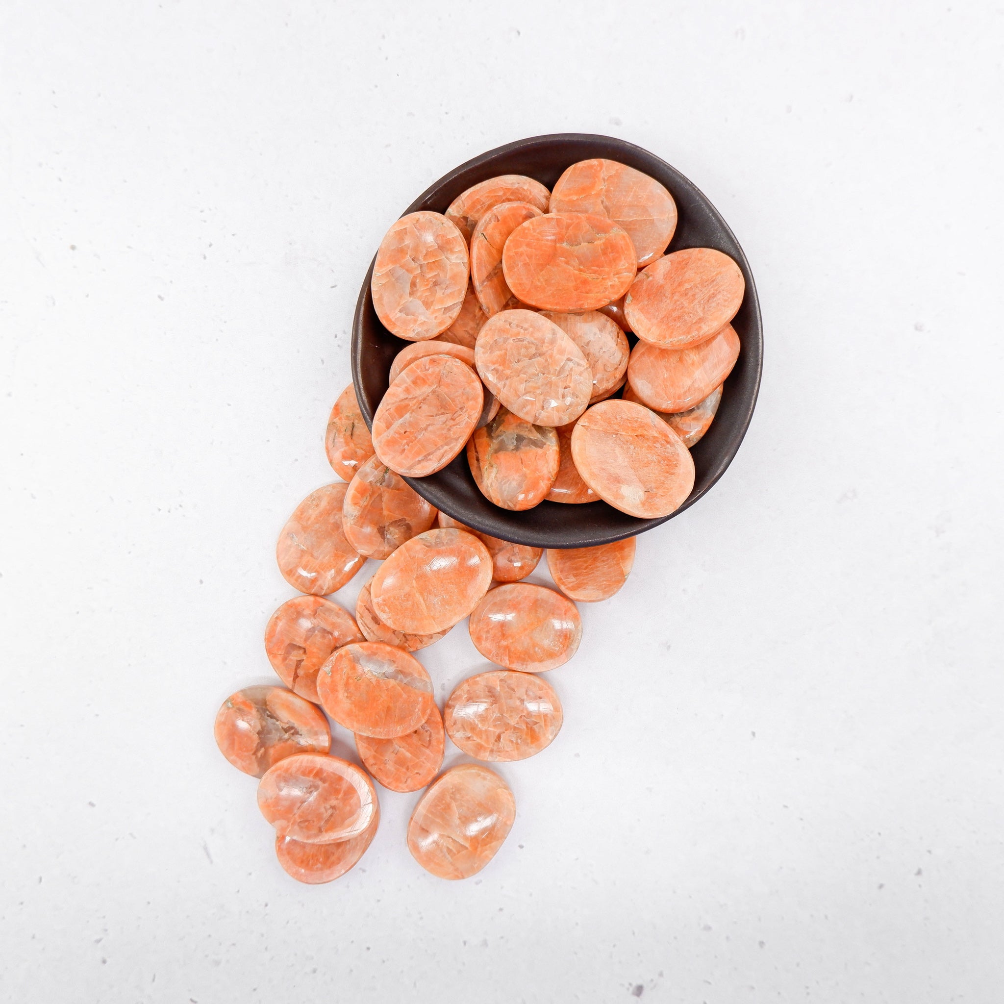 Orange Moonstone worry stone from Noctis Studio featuring smooth, polished orange moonstone with a calming, rounded shape.