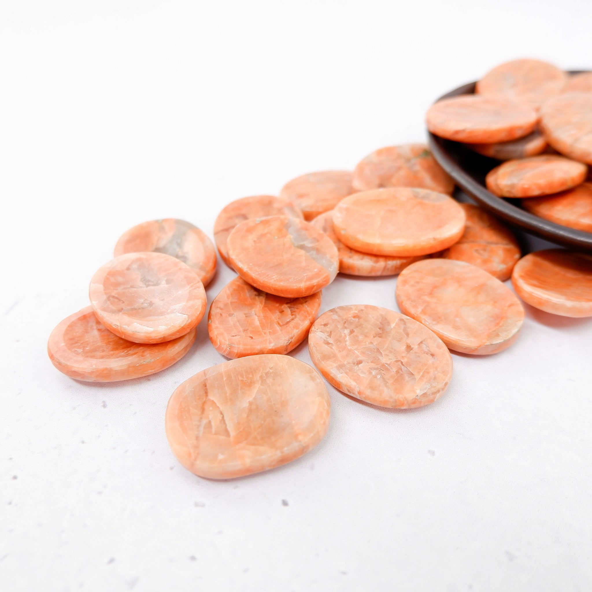 Orange Moonstone worry stone by Noctis Studio featuring a smooth, polished oval shape with vibrant orange and moonstone shimmer.
