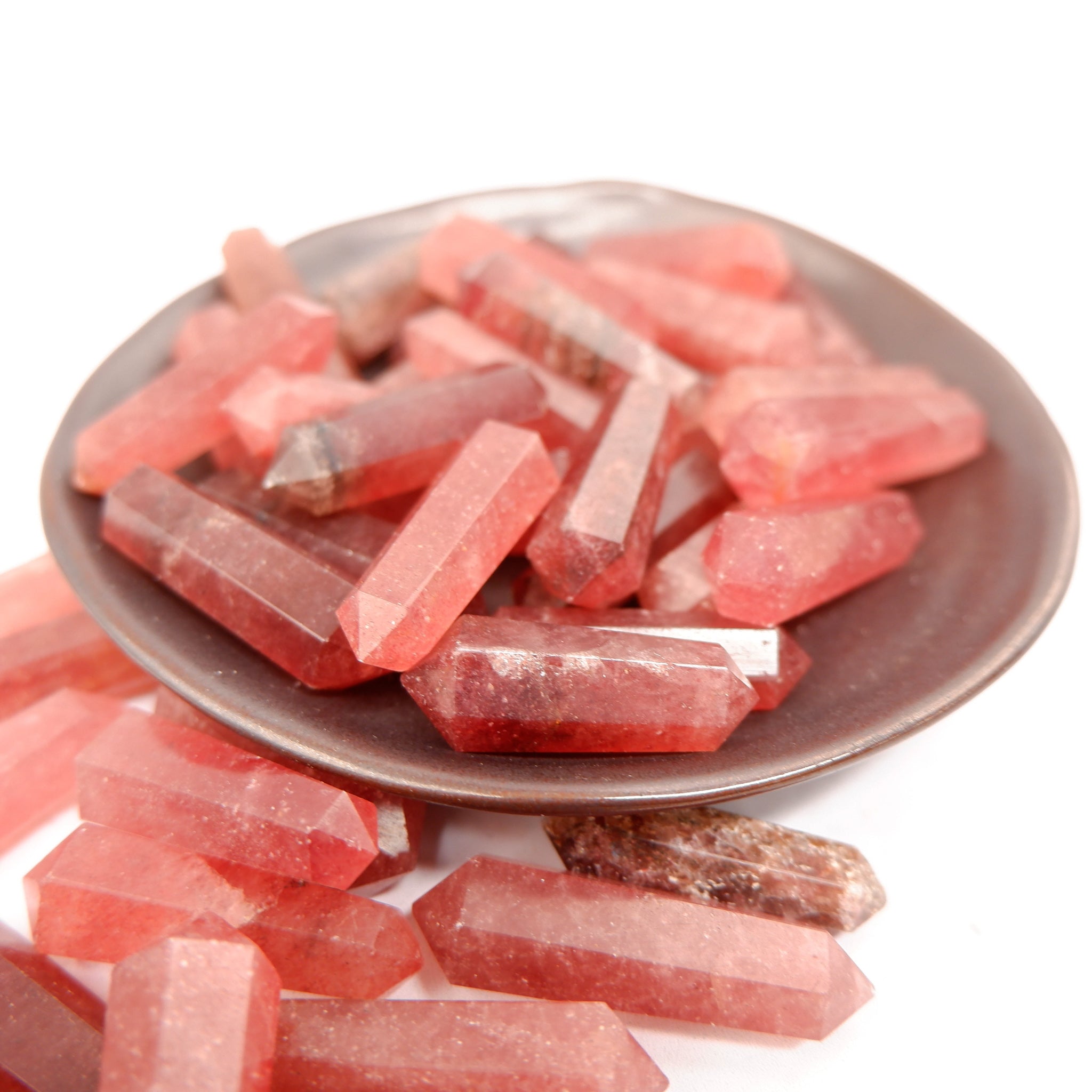 Strawberry Quartz Double Gridding Point by Noctis Studio showing a polished gemstone with a pointed, faceted design.