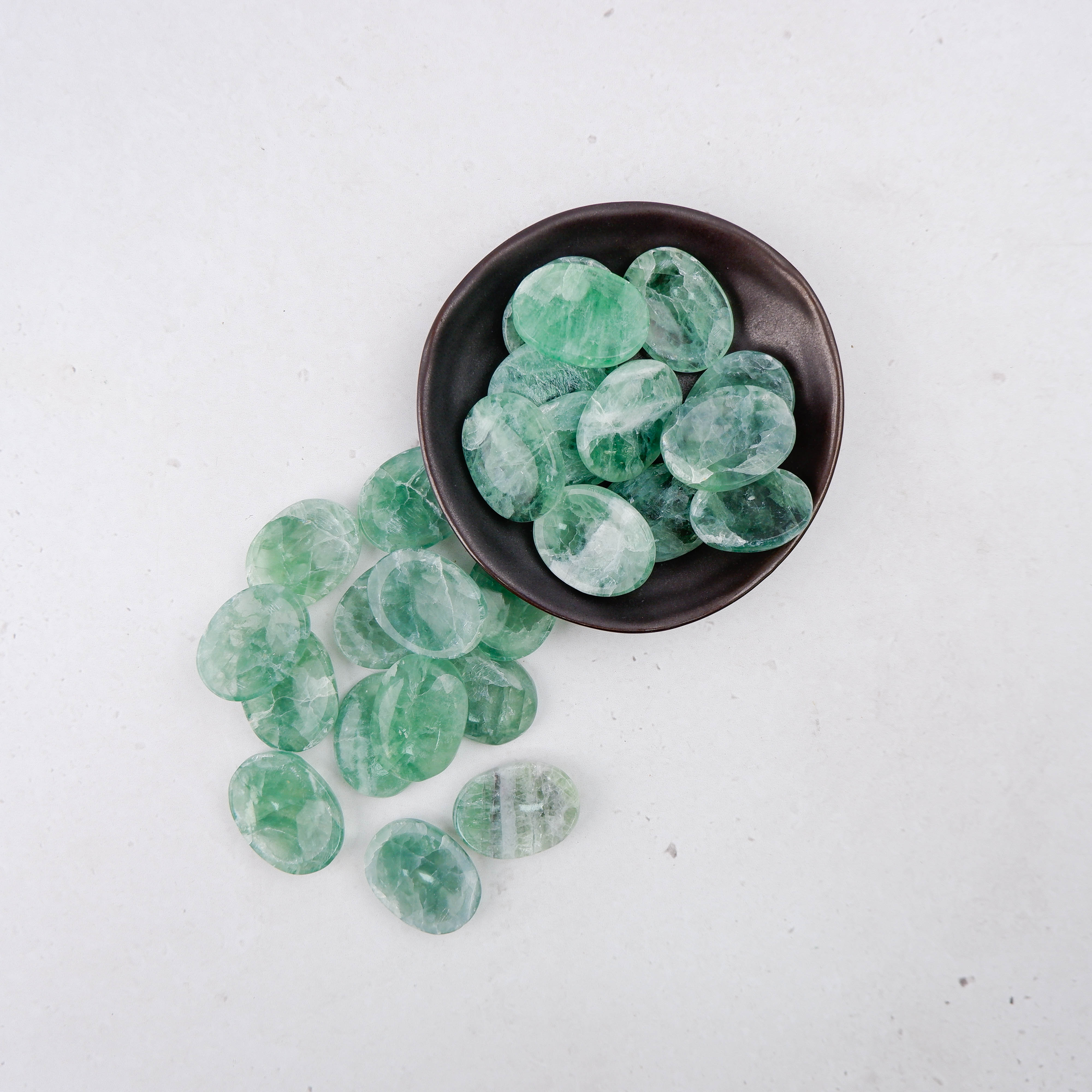 Green fluorite worry stone from Noctis Studio, smooth polished gemstone with calming green hues and natural crystal patterns.
