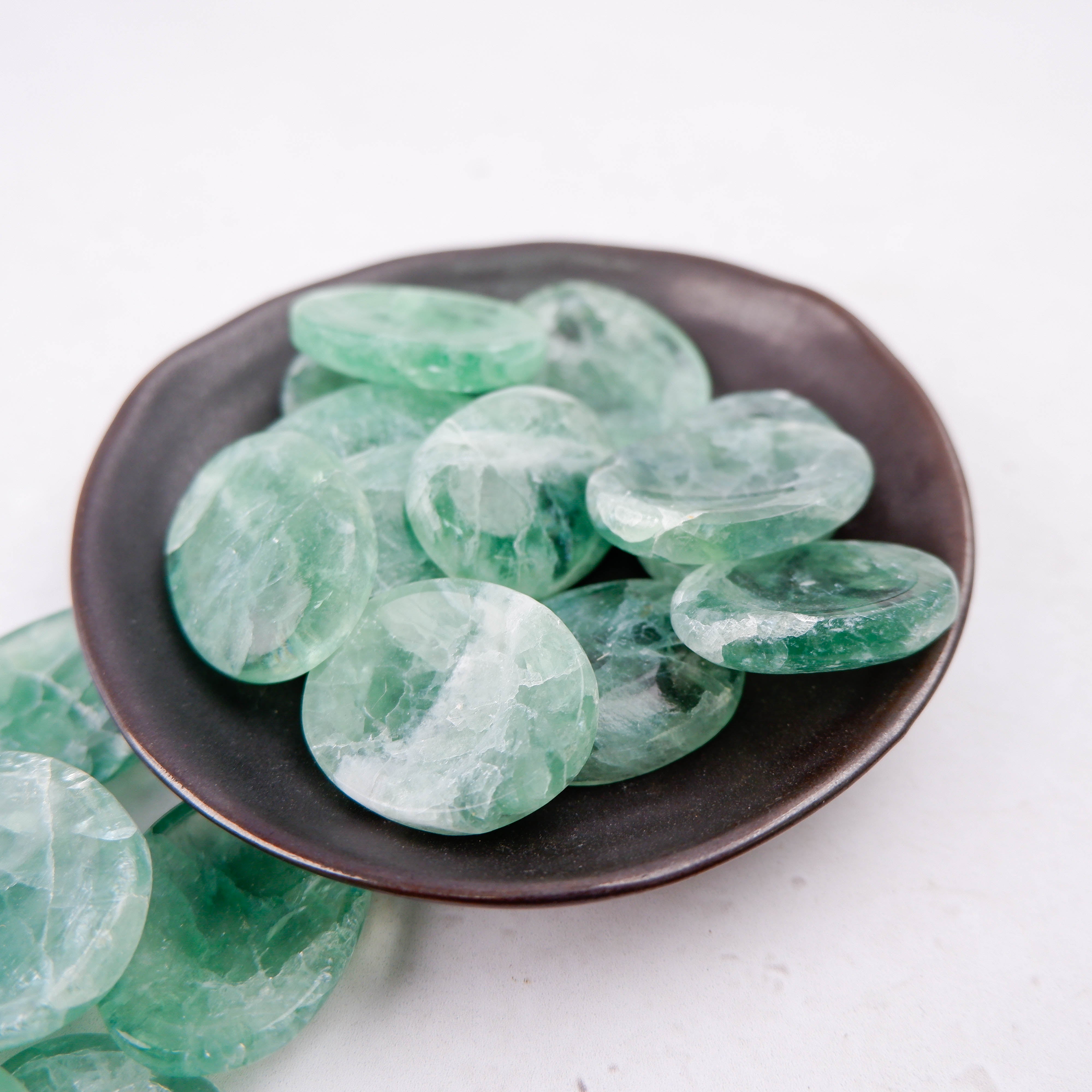Green fluorite worry stone from Noctis Studio with smooth, polished surface and natural green coloration.