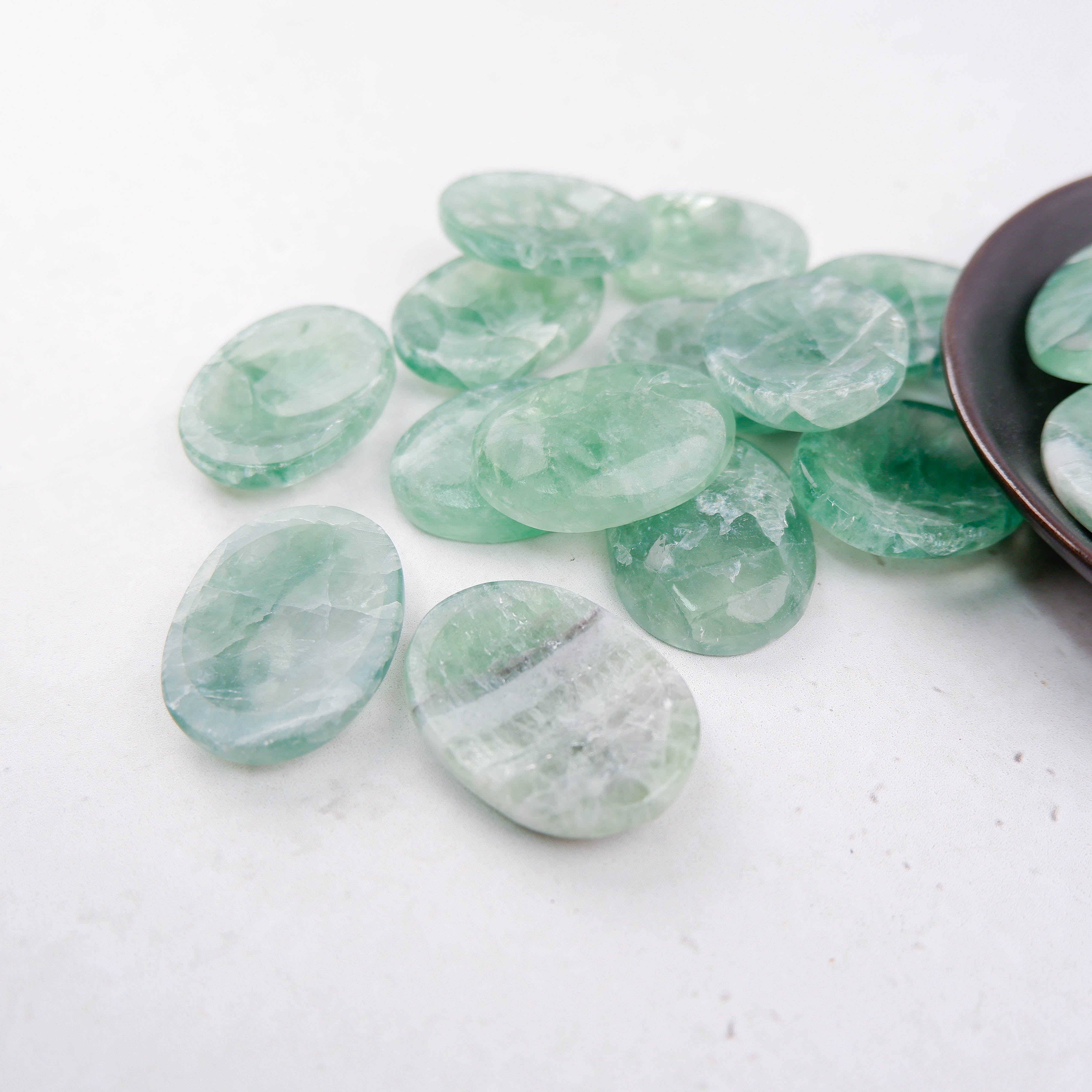 Green fluorite worry stone from Noctis Studio, smooth polished gemstone with vibrant green hues for calming and meditation.