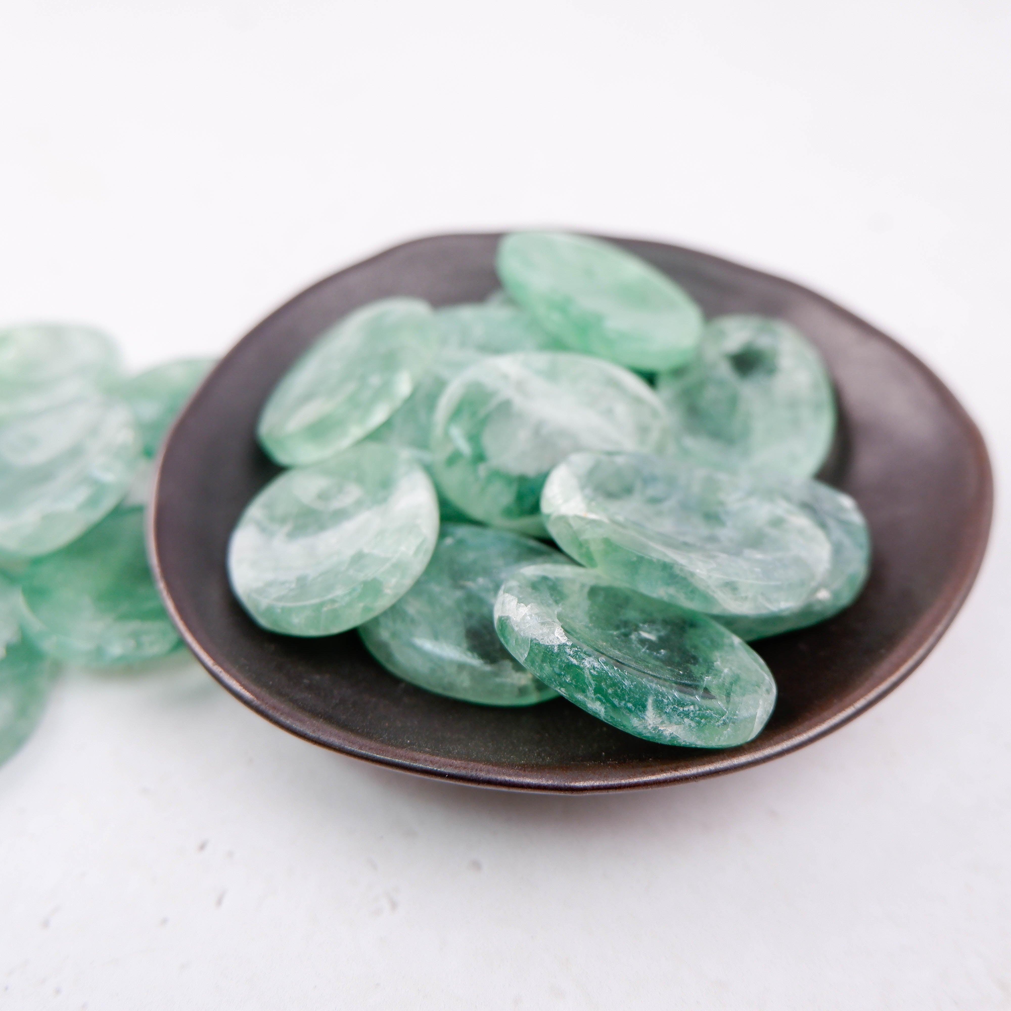 Green fluorite worry stone from Noctis Studio showing smooth, polished surface and vibrant green color.