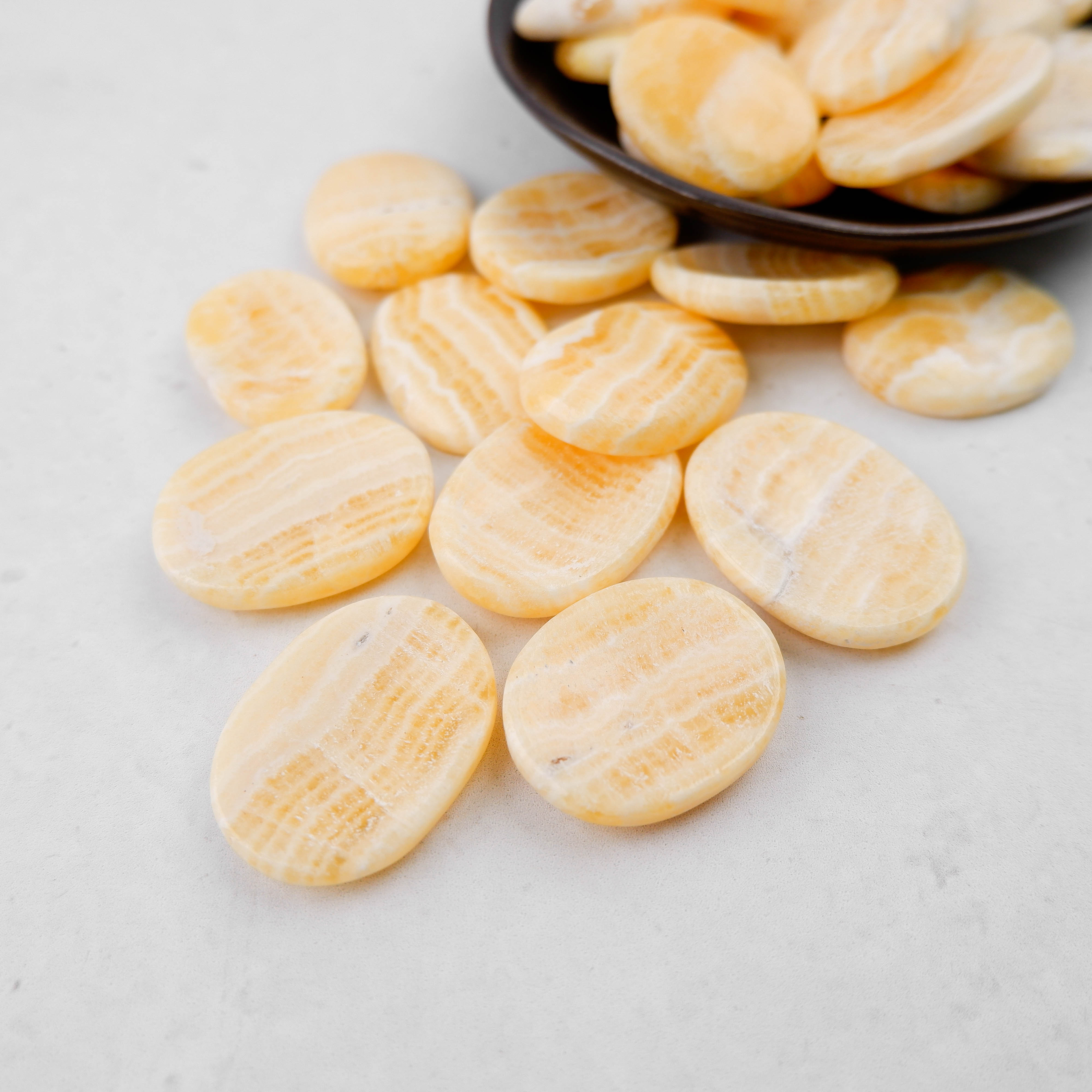 Orange Banded Calcite worry stone from Noctis Studio, smooth polished gemstone with vibrant orange banding and calming appearance.