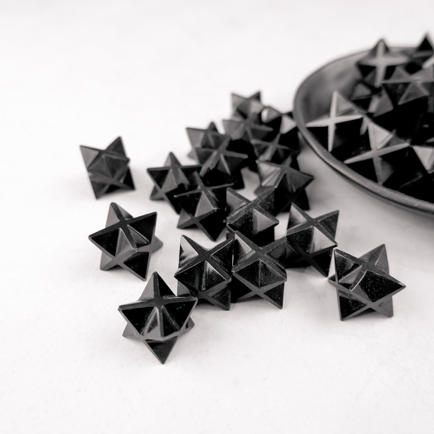 Dark obsidian star sculpture by Noctis Studio, featuring a polished, natural star-shaped mineral with a smooth, reflective surface.