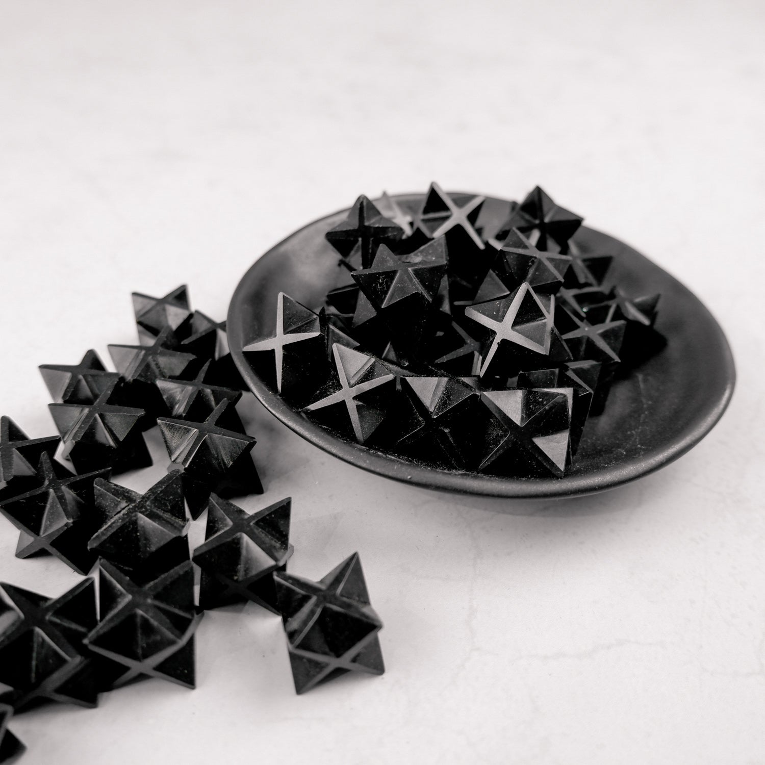 Black obsidian star sculpture by Noctis Studio, with smooth polished surface and detailed star shape on a neutral background.