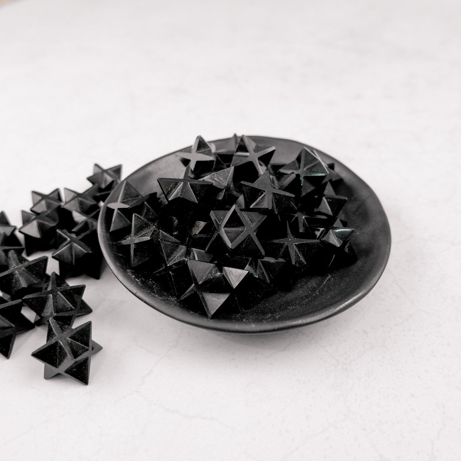 Noctis Studio Obsidian Star sculpture with a smooth, glossy black surface and star shape, displayed on a neutral background.