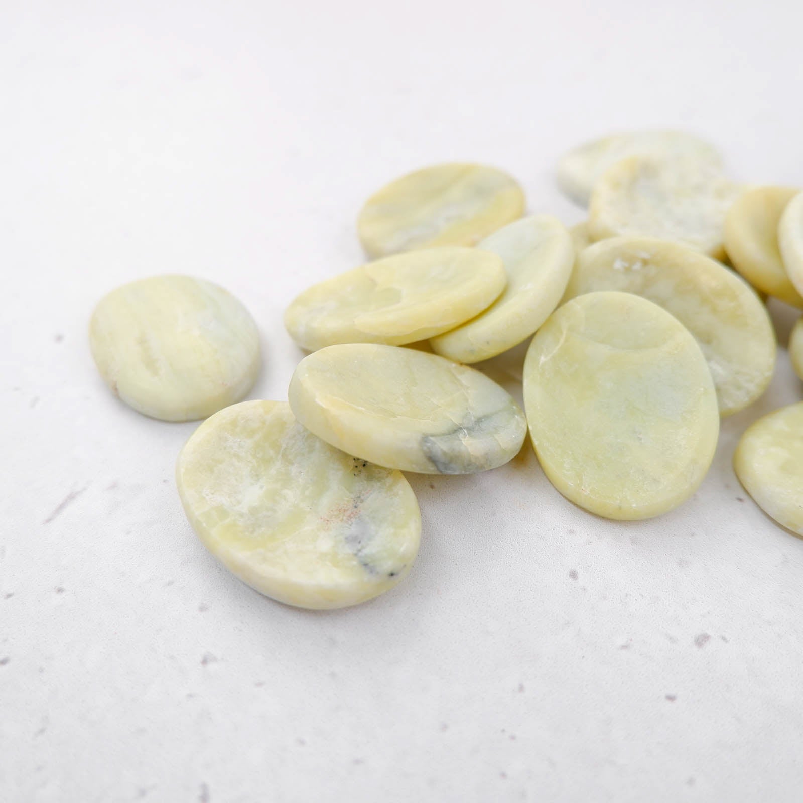 Serpentine worry stone by Noctis Studio showing smooth polished green stone with natural swirls and rounded shape for stress relief.