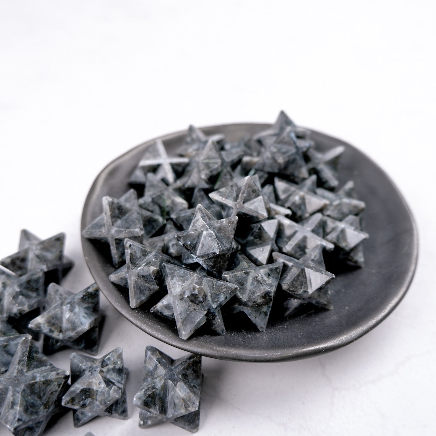 Larvikite star-shaped sculpture by Noctis Studio, showcasing polished dark stone with natural mineral patterns and star shape design.