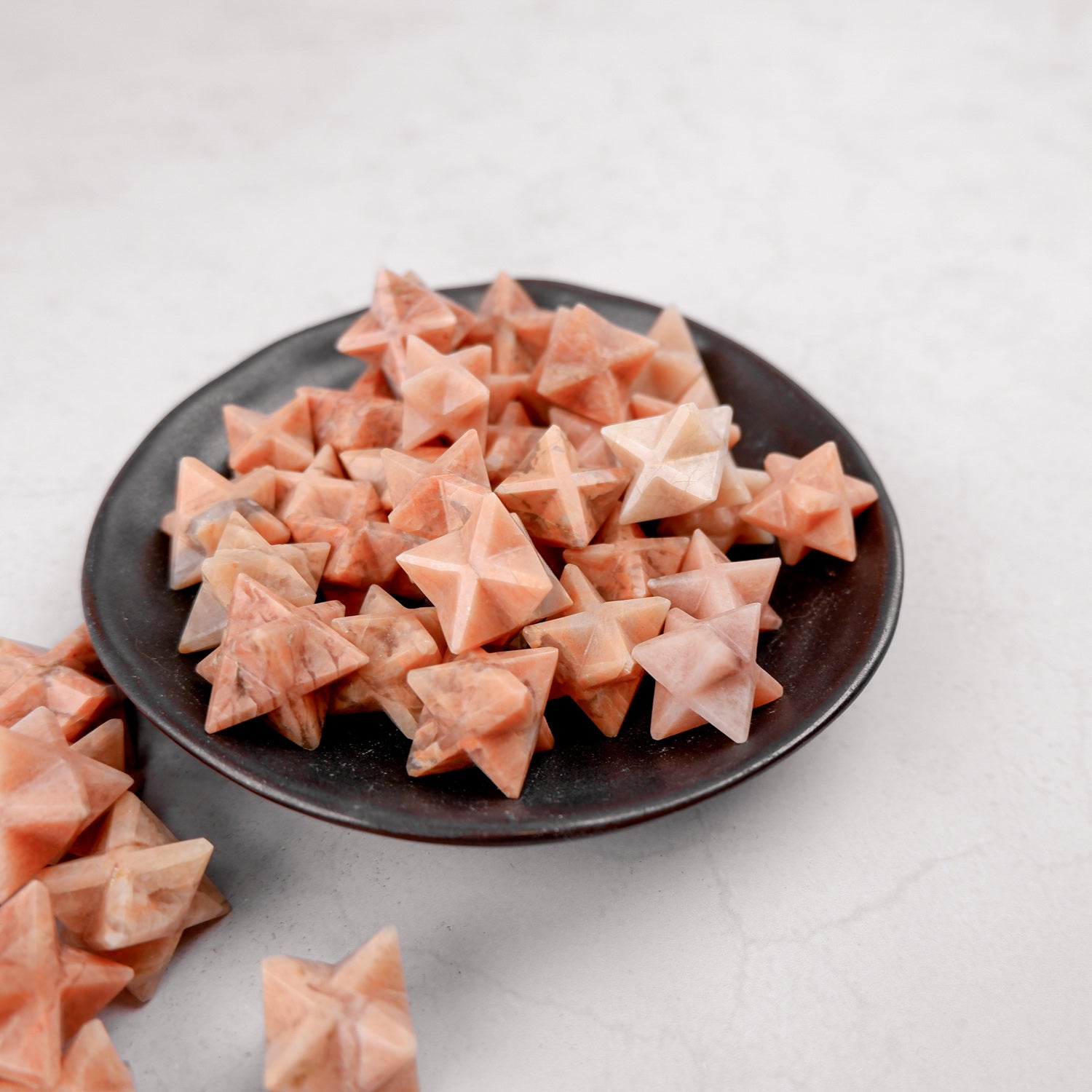 Orange moonstone star jewelry piece from Noctis Studio, showcasing a polished star-shaped gemstone with vibrant orange hues.