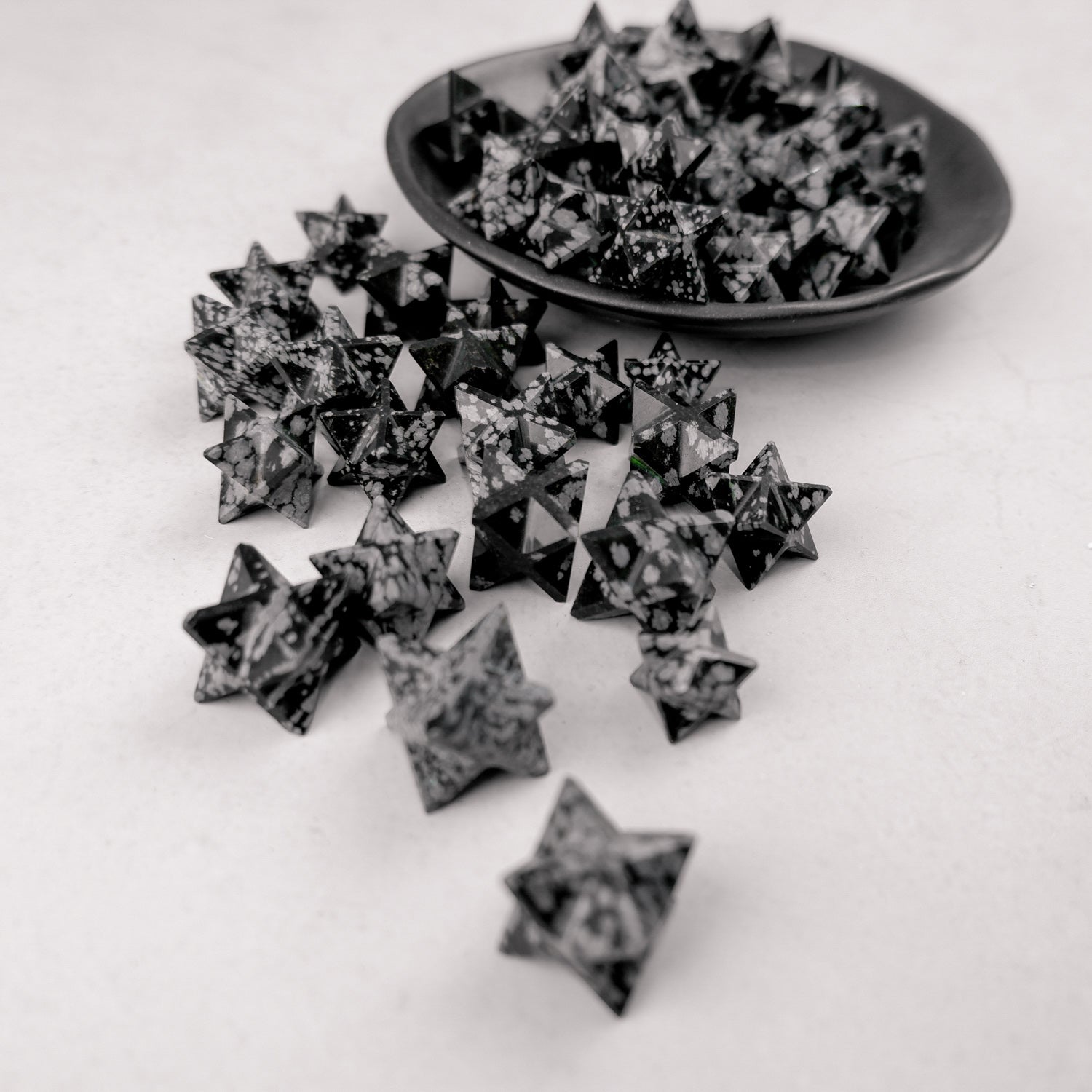 Snowflake Obsidian star sculpture by Noctis Studio, featuring a polished star with distinctive white snowflake patterns on black volcanic glass.