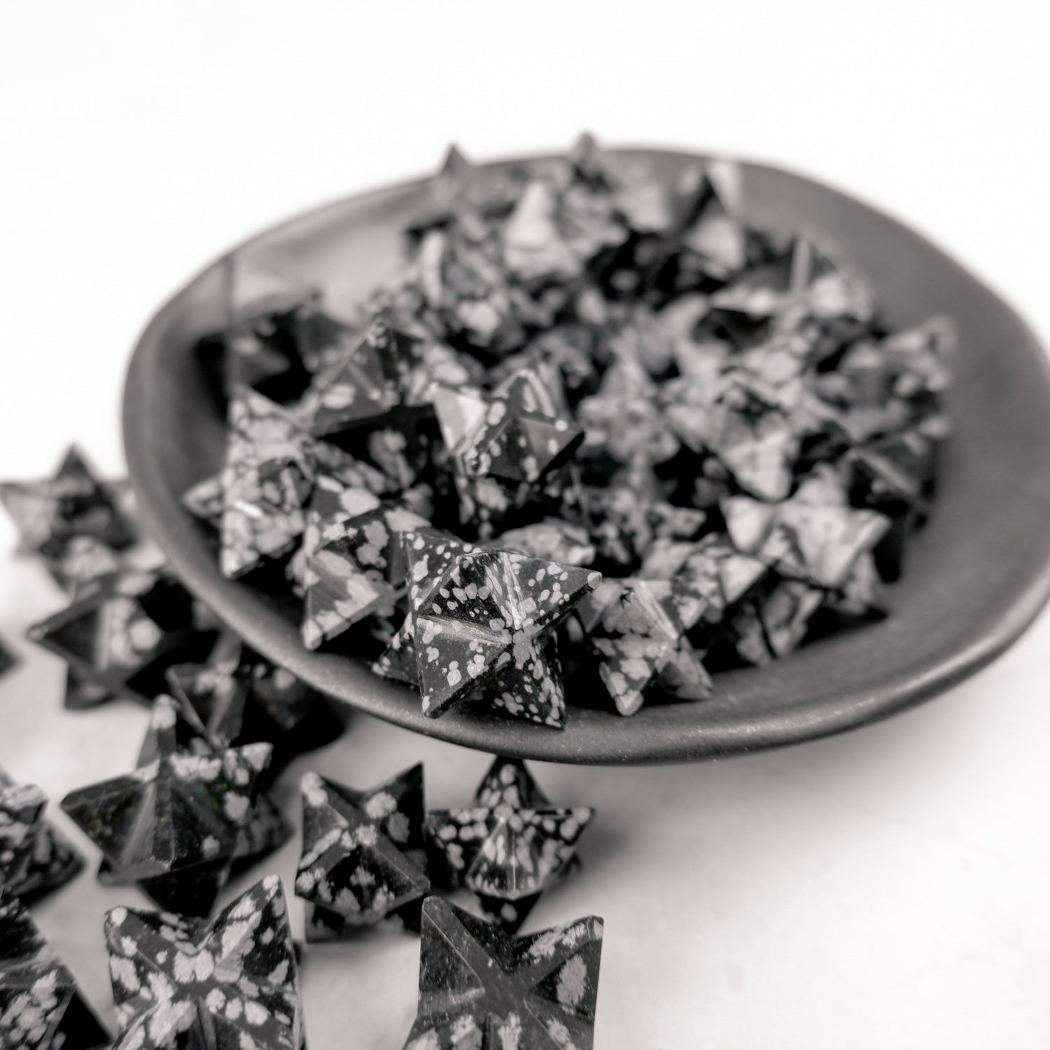 Snowflake Obsidian star sculpture by Noctis Studio, featuring a polished black star with white snowflake-like mineral patterns.