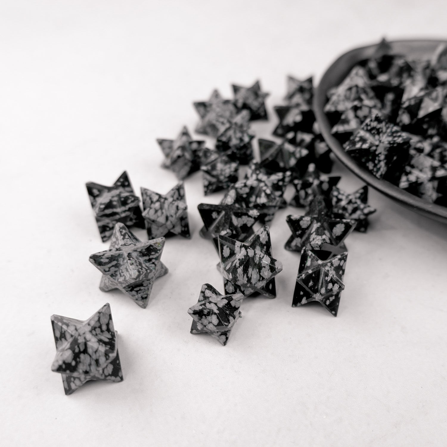 Snowflake Obsidian star from Noctis Studio, polished black stone with white snowflake patterns, crafted into a decorative star shape.