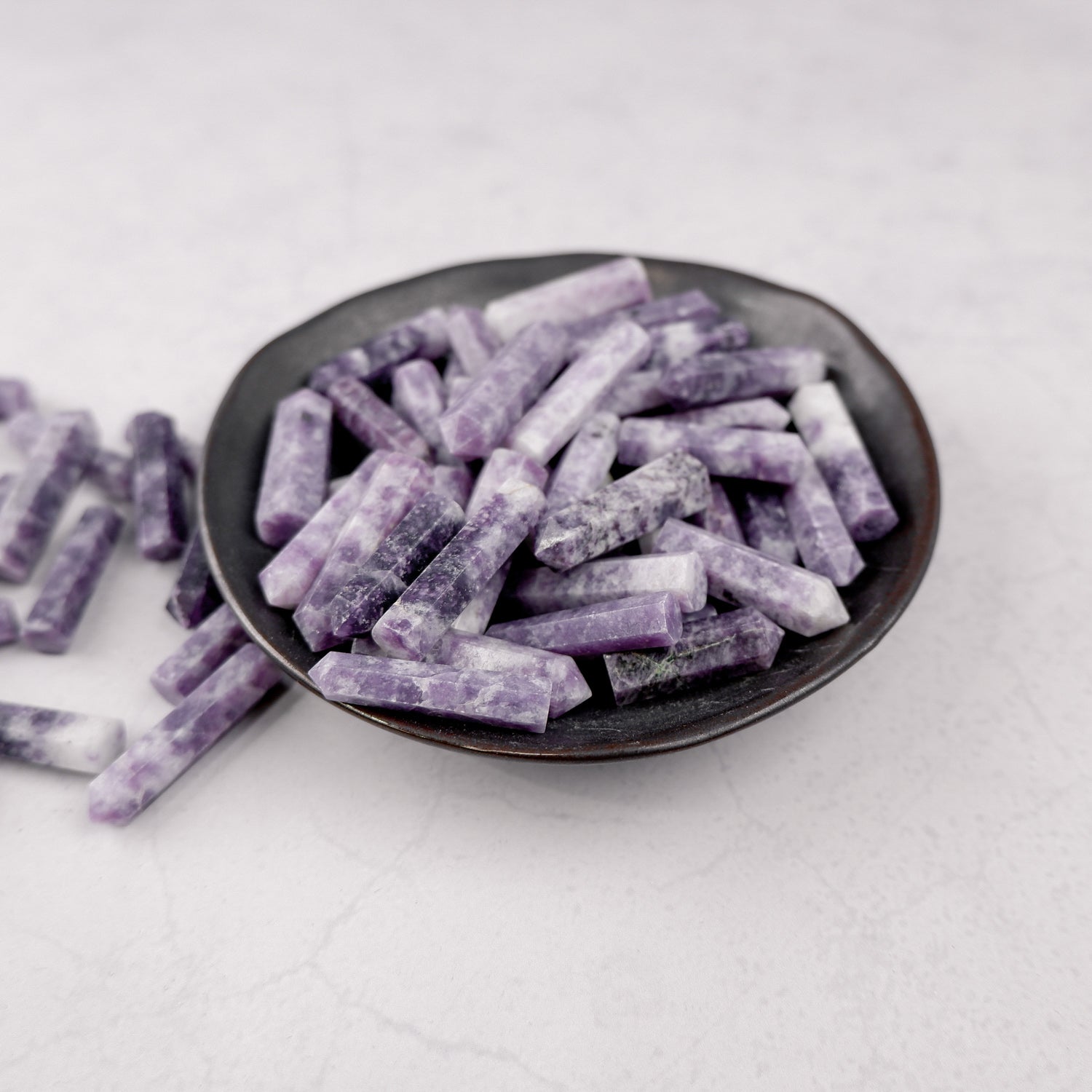 Lepidolite single gridding point by Noctis Studio, showcasing a polished purple crystal with natural striations and pointed tip.