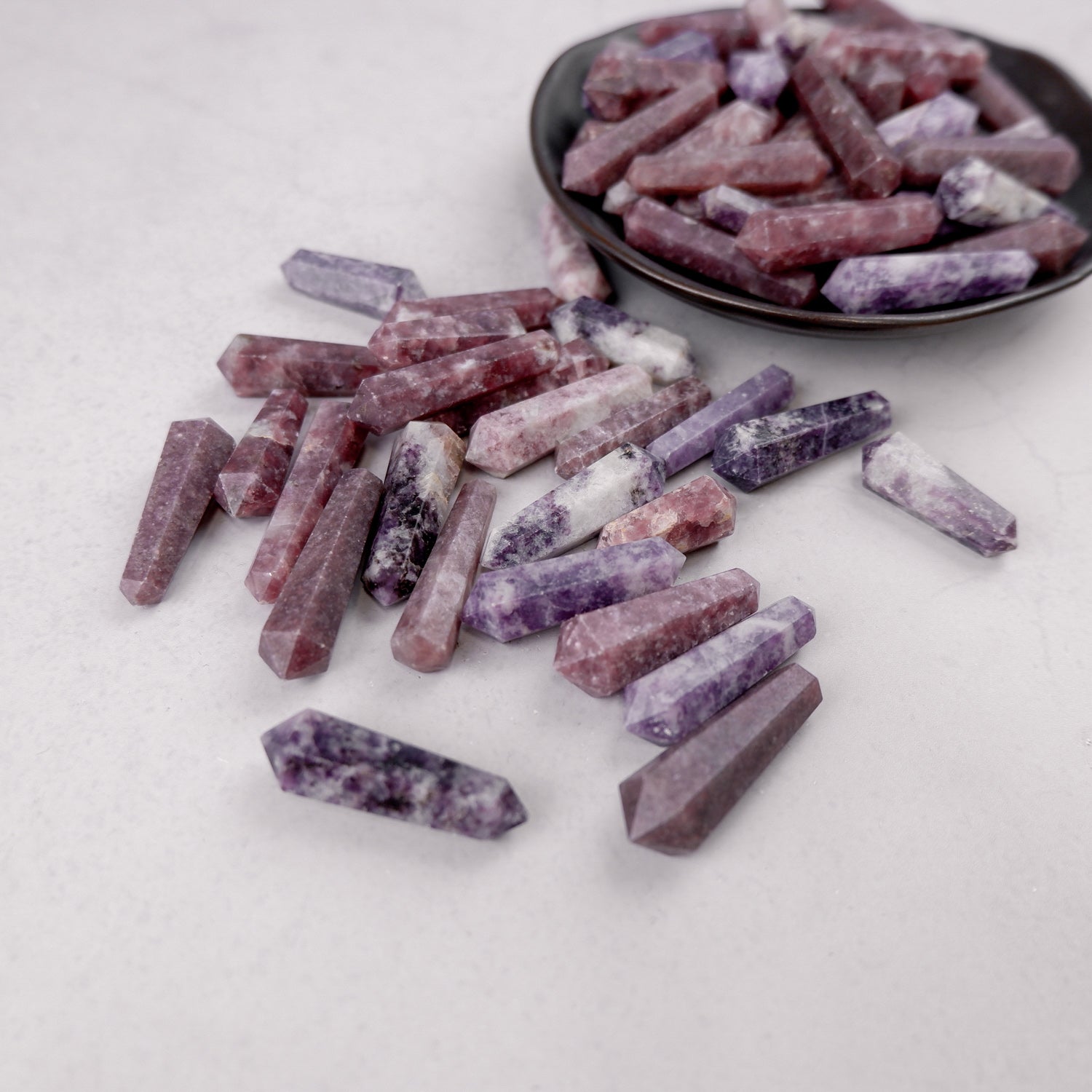 Lepidolite double gridding point from Noctis Studio with purple and pink mineral details on a clear base.