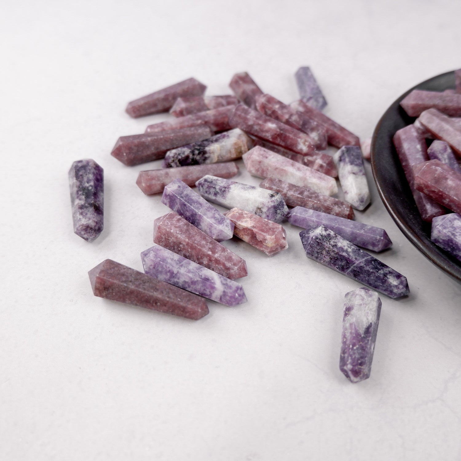 Lepidolite double gridding point gemstone from Noctis Studio, showcasing purple and pink hues with natural crystal formations.