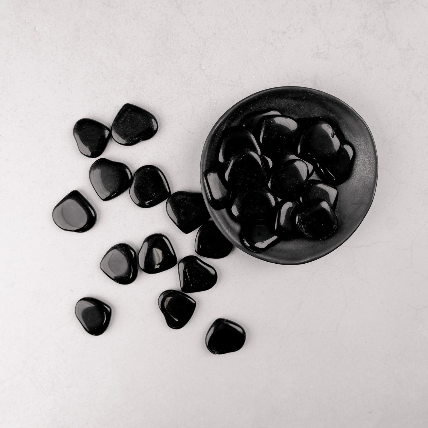 Dark obsidian heart sculpture by Noctis Studio, polished and smooth with a reflective surface on a neutral background.