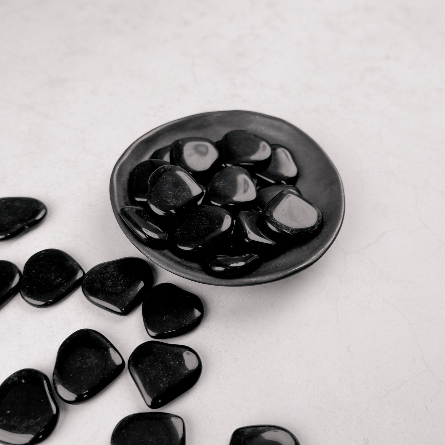 Dark obsidian heart sculpture by Noctis Studio, smooth black stone with polished finish, resting on a neutral background.